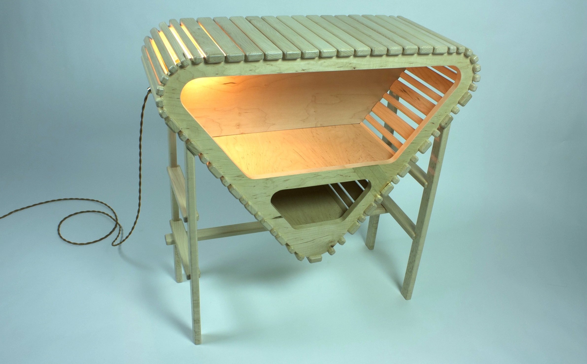 This sideboard plays with the exposure of both structure and contents through the repetition of smaller components forming a slat-and-scaffolding design. Liquor and other vices can be displayed proudly in the interior with light escaping throu