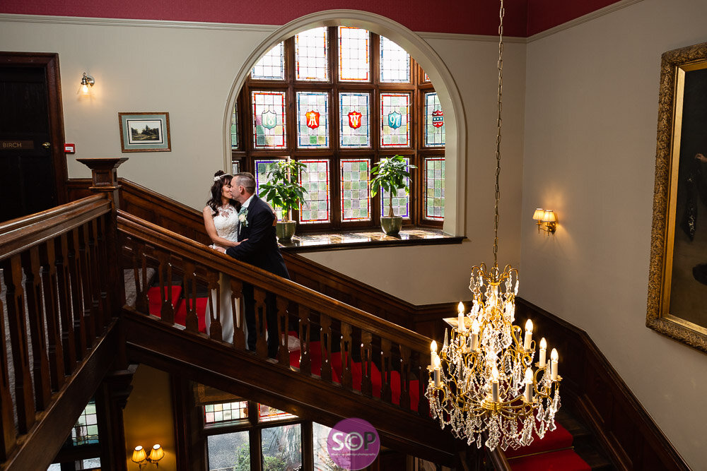 bride and groom on the stairs with chandelier at the ilife in coventry