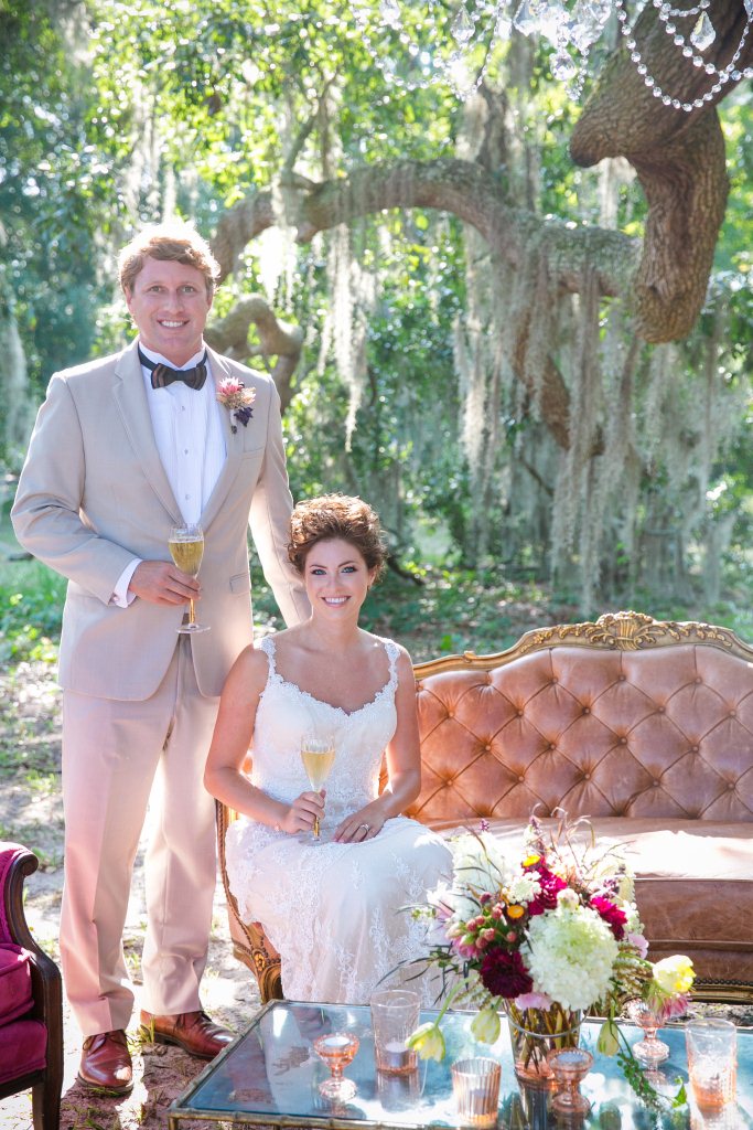 A bride and groom posing under an oak tree