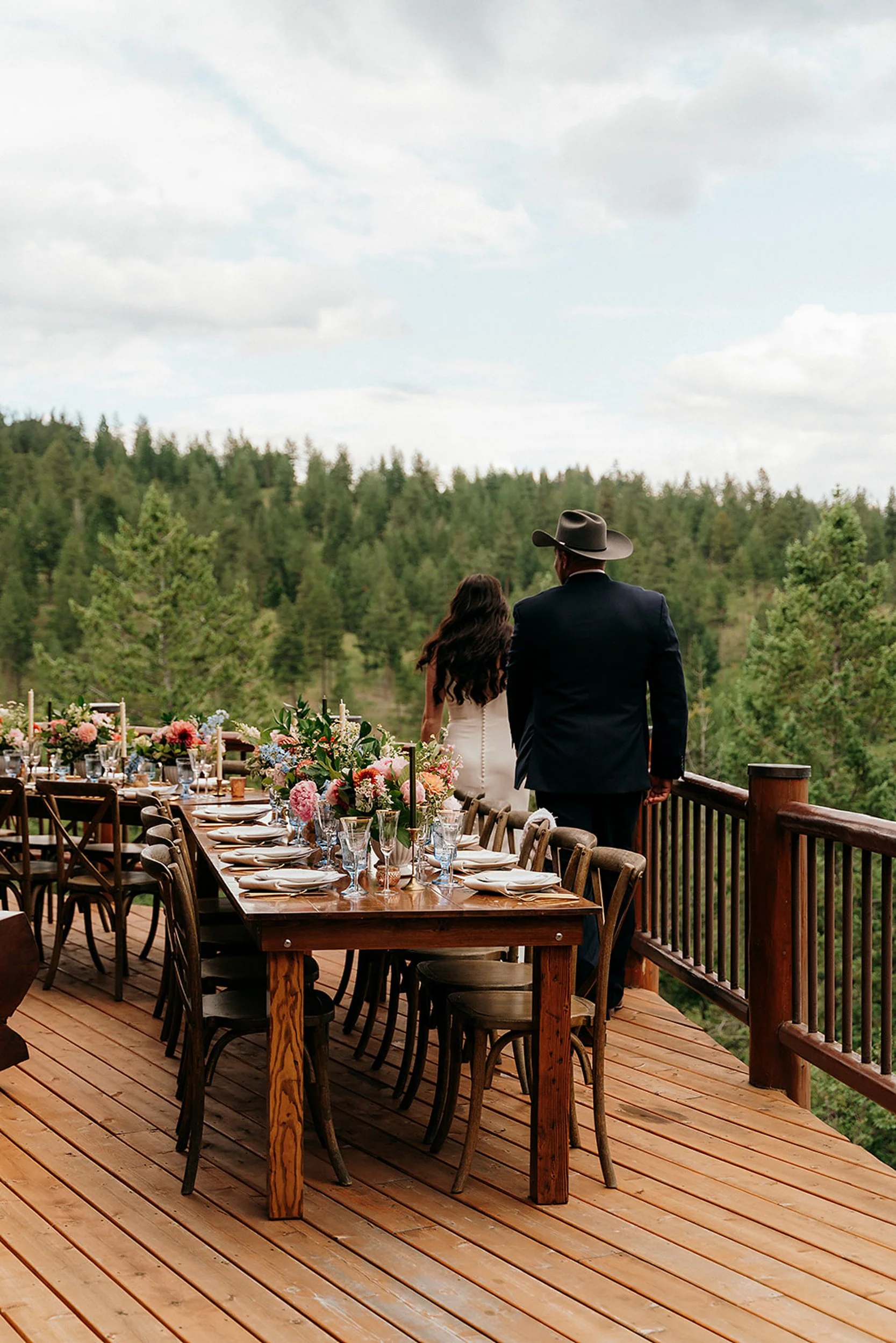 bride and groom walk on balcony with reception tables