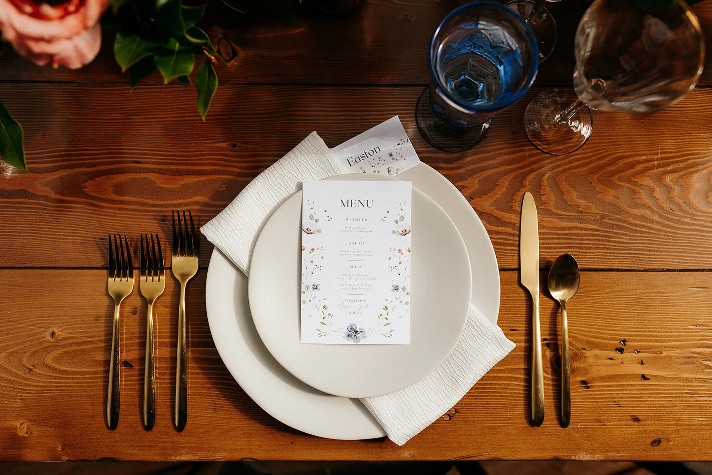 table with plates, menu, cutlery, and glasses