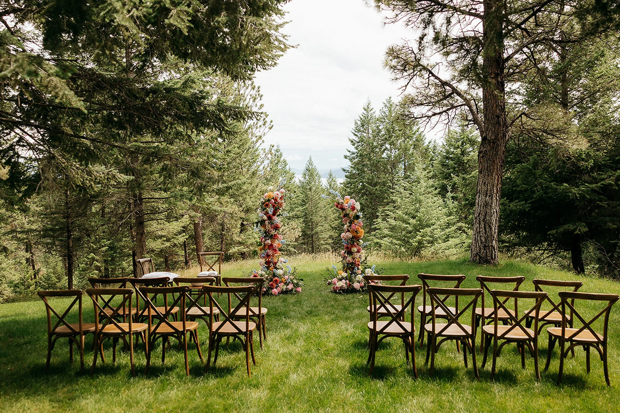 floral arbor with wooden chairs in lawn