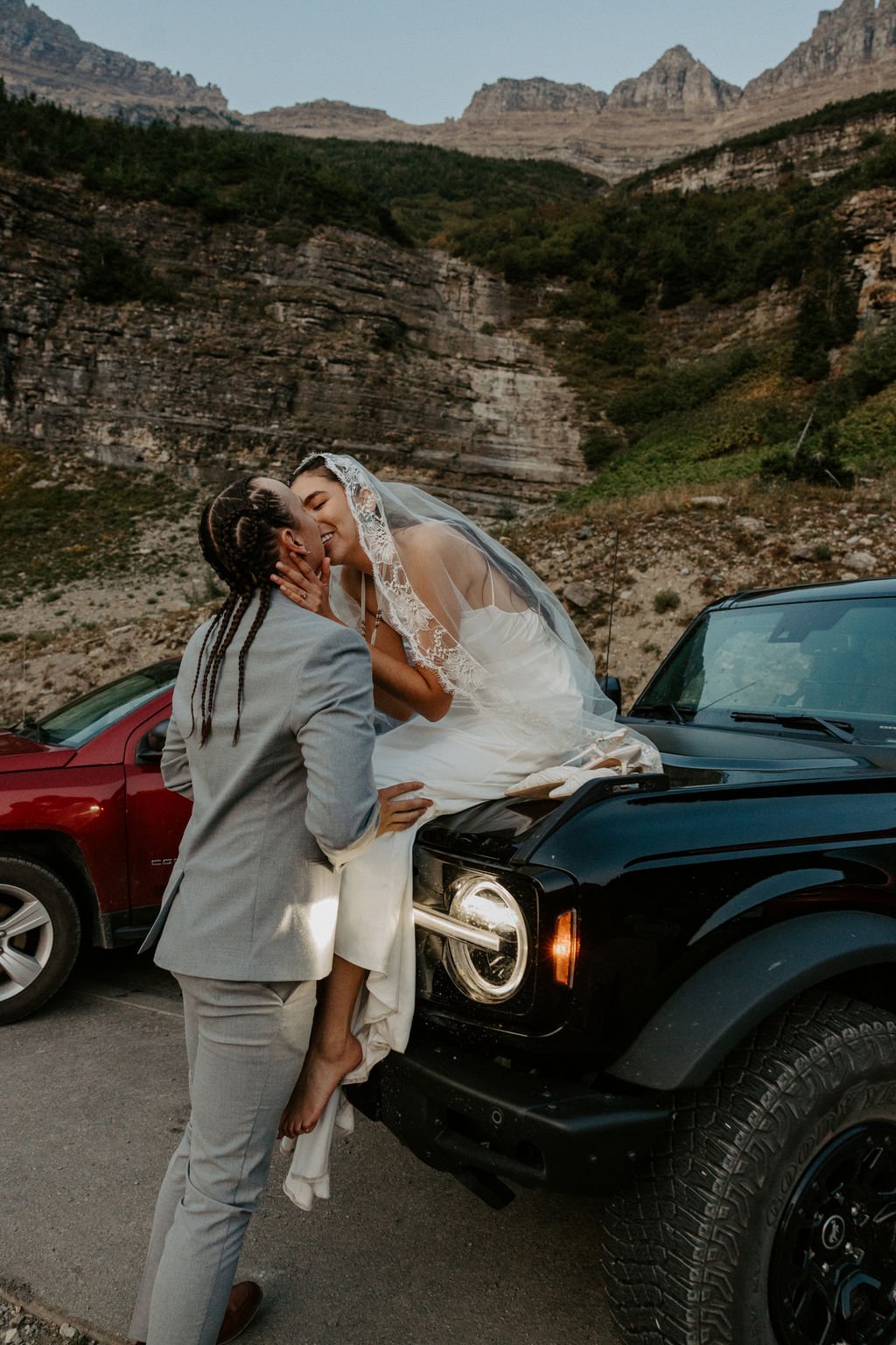Couple kissing on car at Big Bend in Glacier National Park