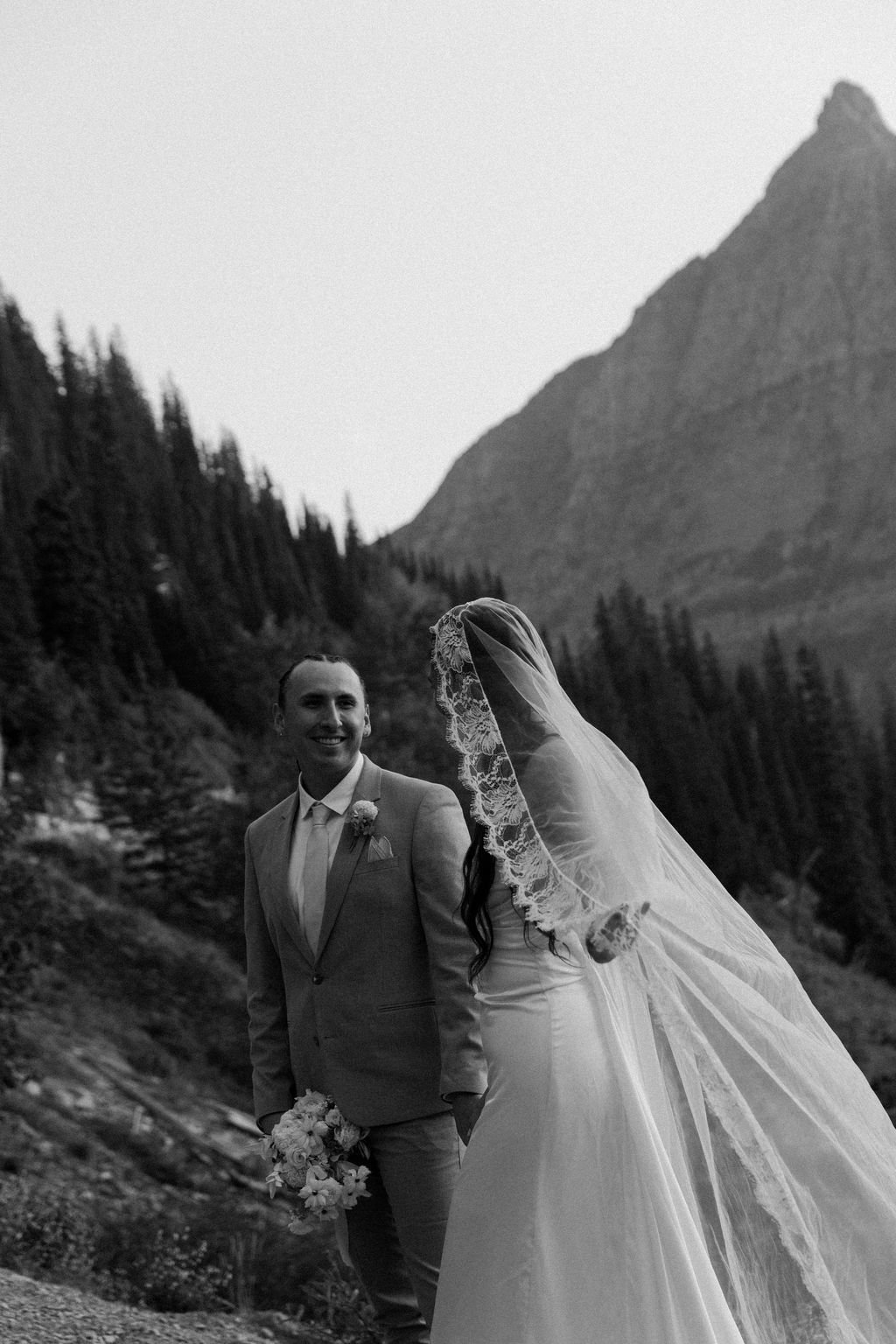 Black and white of bride and groom looking at each other smiling at Big Bend in Glacier National Park