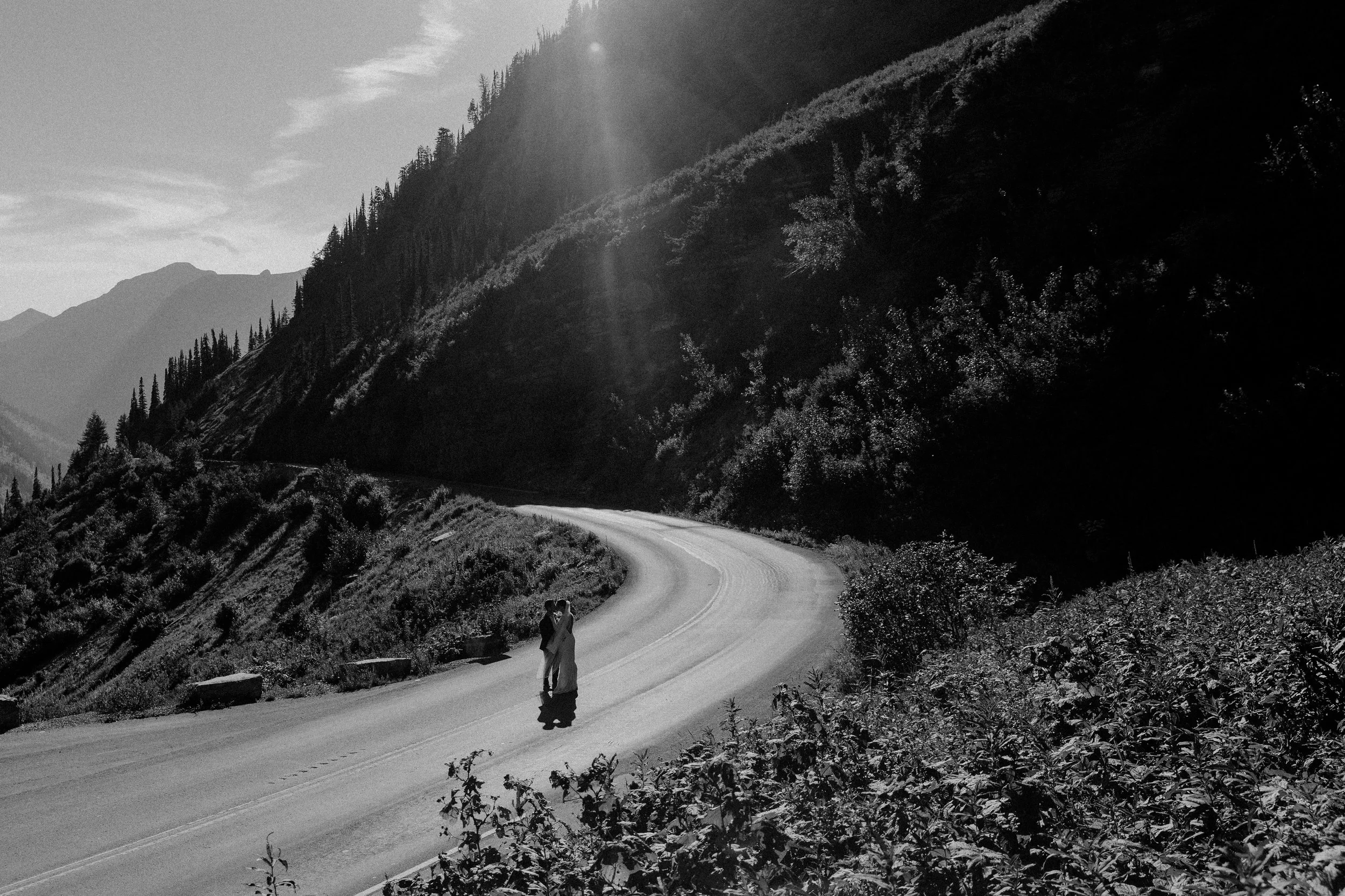 Bride and groom kissing on Going to the Sun Road at Big Bend in Glacier National Park