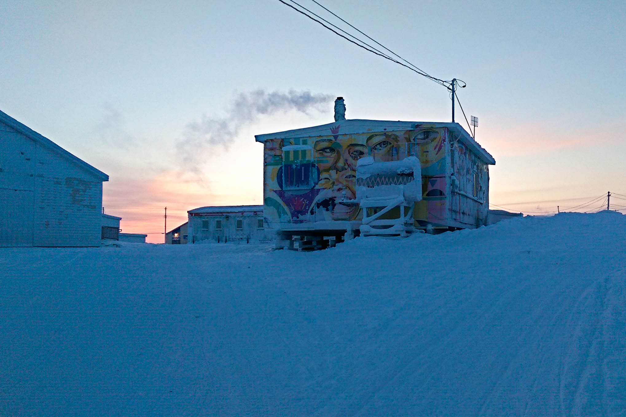 Colourful graffiti on the Igloolik Radio Station at sunrise. Photo by Denis Thibeault.