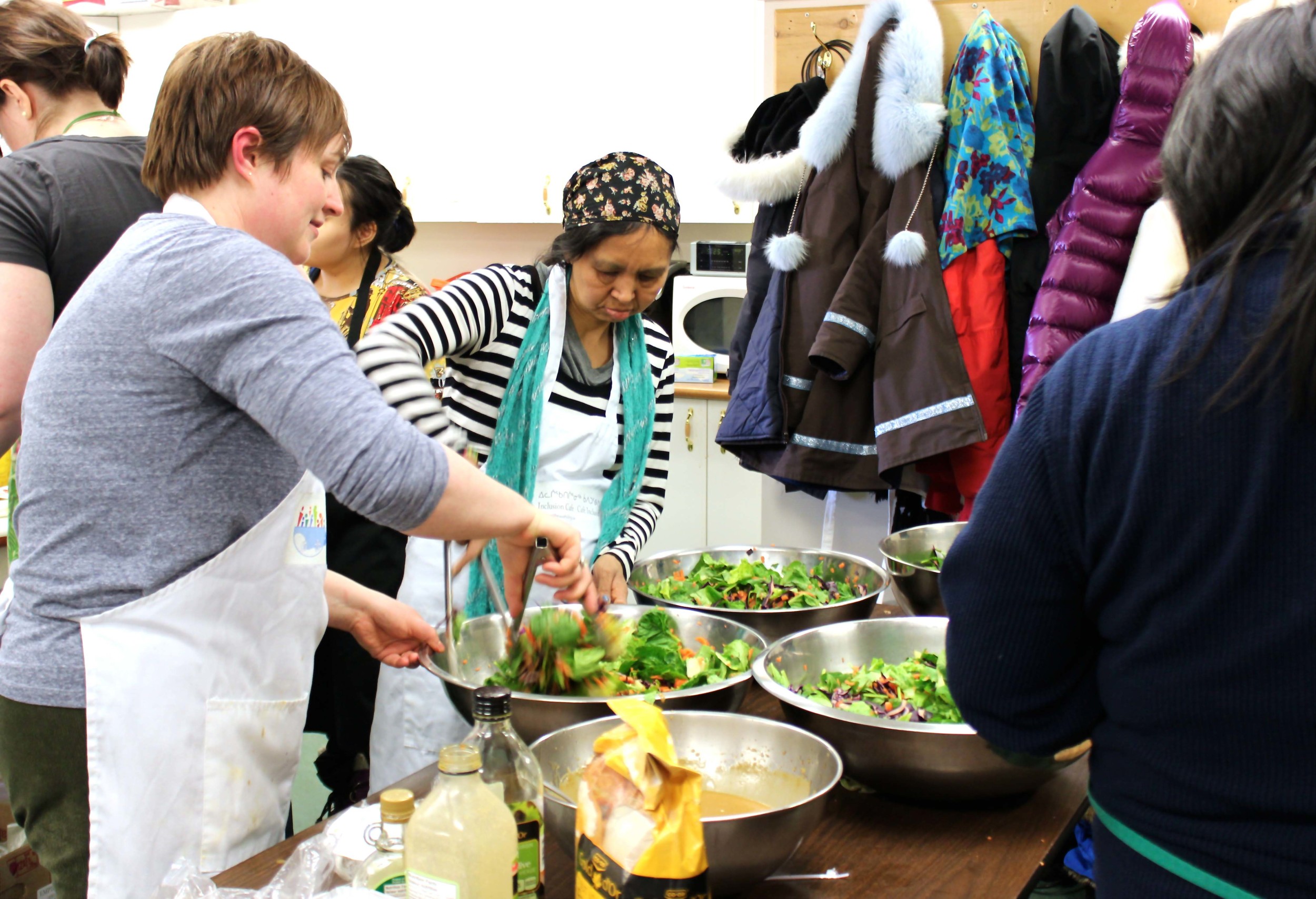 Inclusion Café's volunteers and staff busily prepare a healthy salad for dinner. Photo by Sarah Brandvold.
