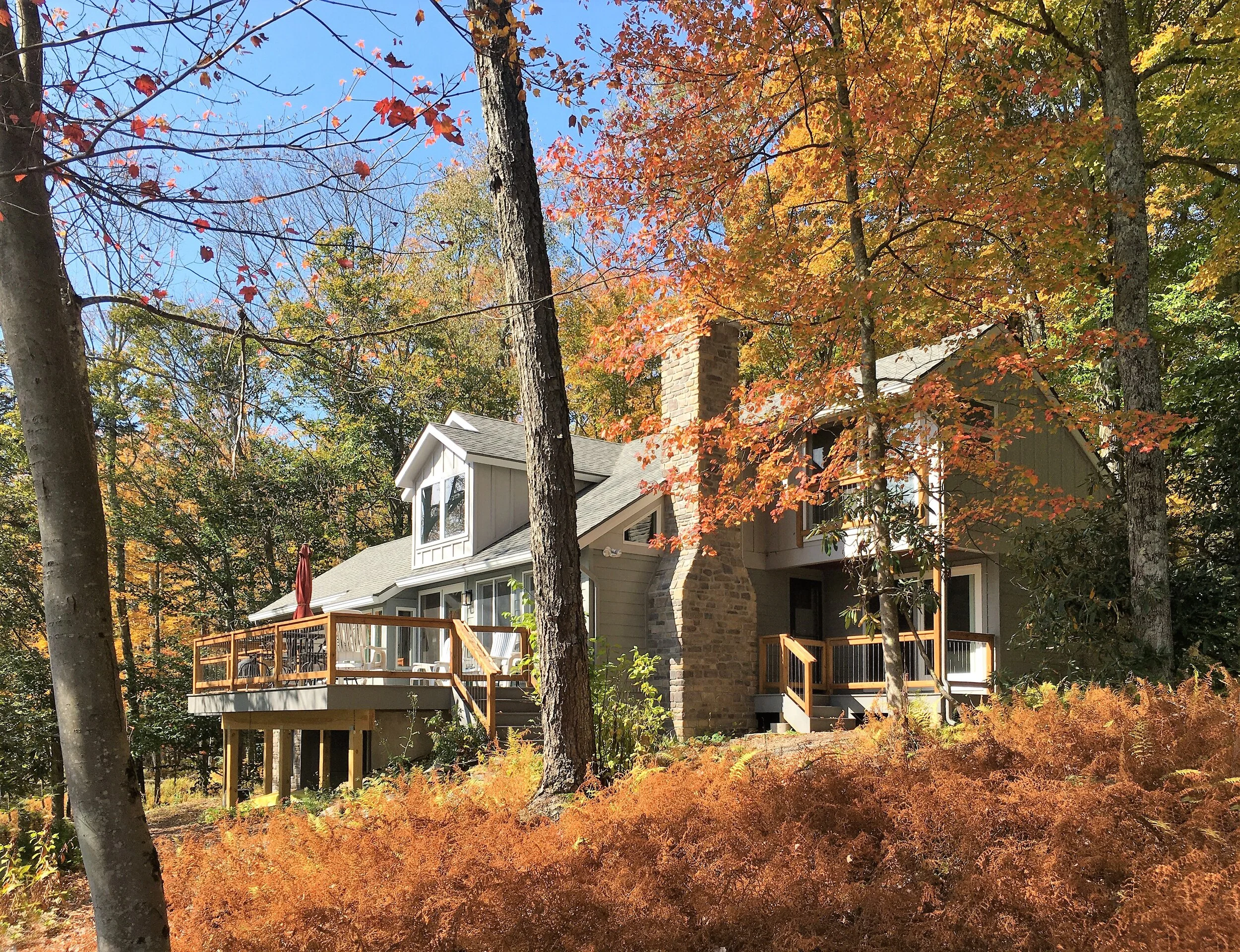  View of the lake-facing facade. A cantilevered extension was added to the existing deck. The concrete block chimney was clad in veneer stone.  