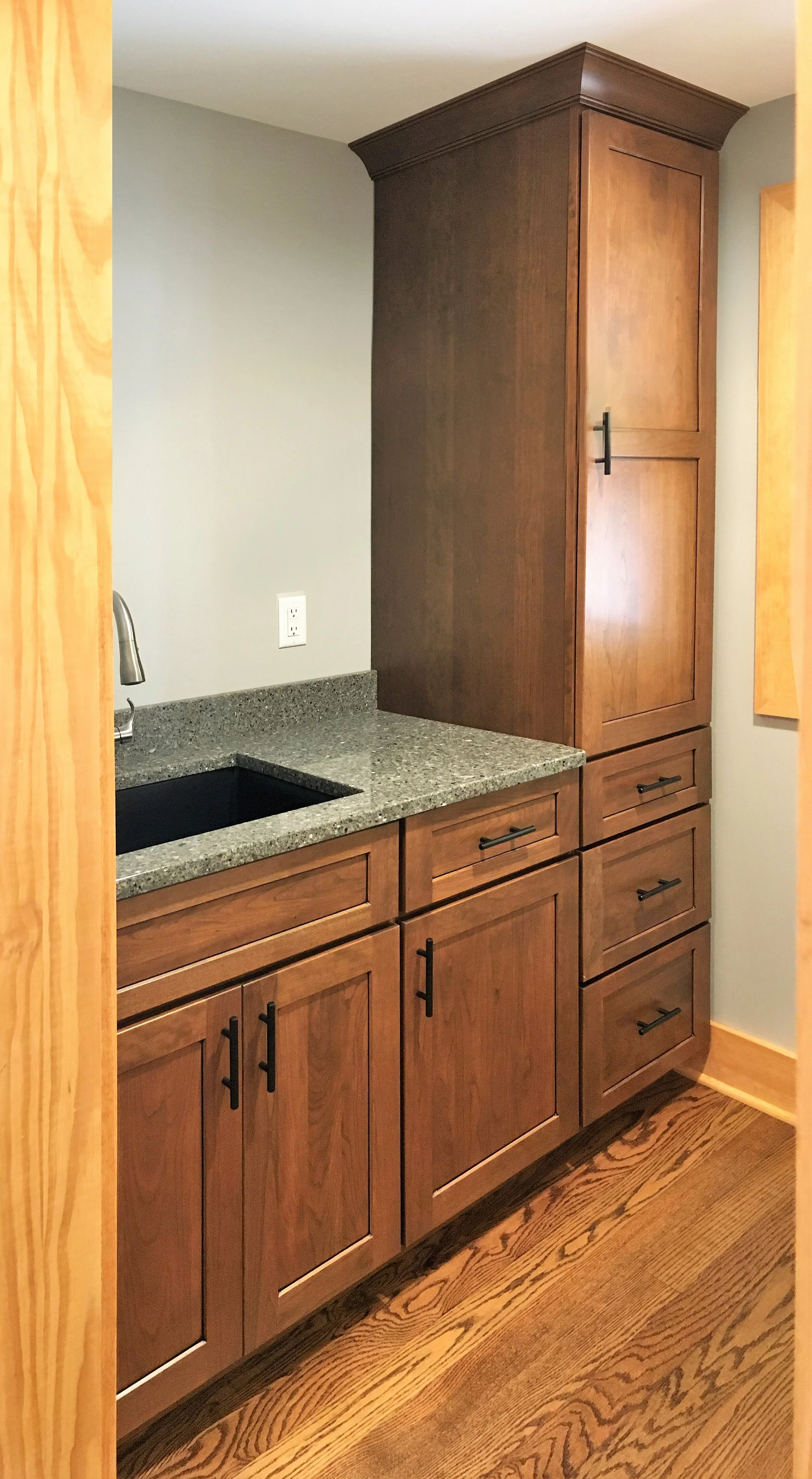  The new laundry room is behind a pocket door and features custom maple cabinetry.  