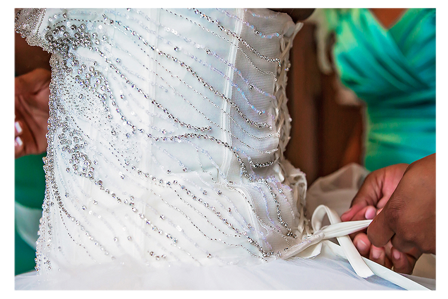 Maid of Honor tying up the brides dress