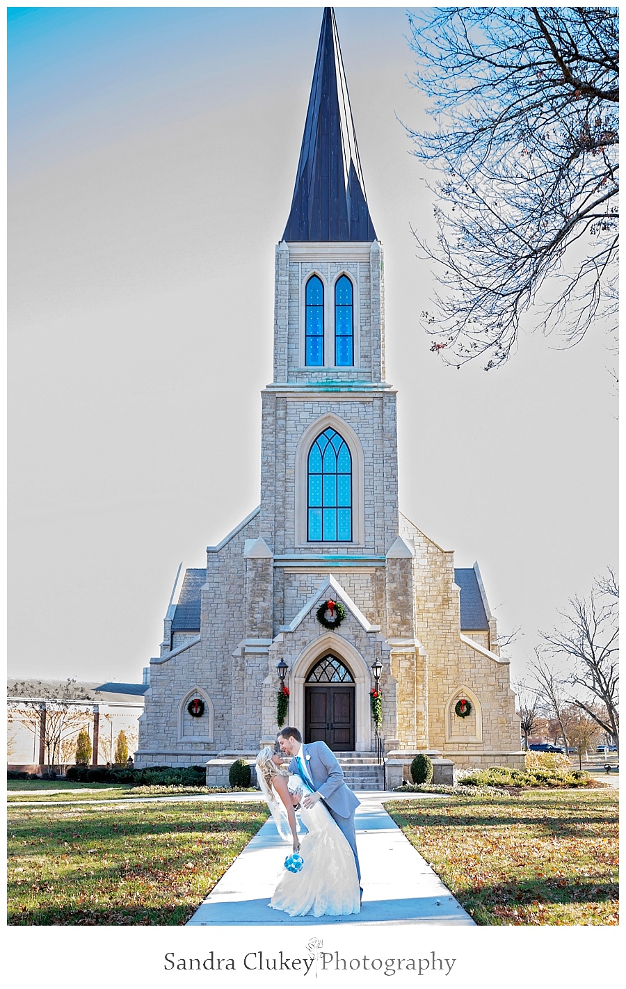 Groom dips bride in front of Chapel