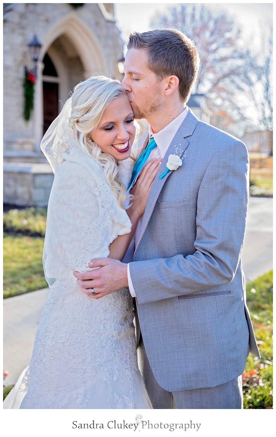 Groom kisses Bride in front of Chapel