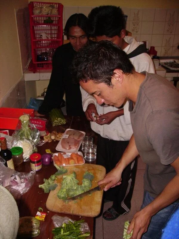 Uno de nuestros ex Voluntarios cocinando junto a los estudiantes. Helping Hands ha acogido a 35 voluntarios de varias partes del mundo.