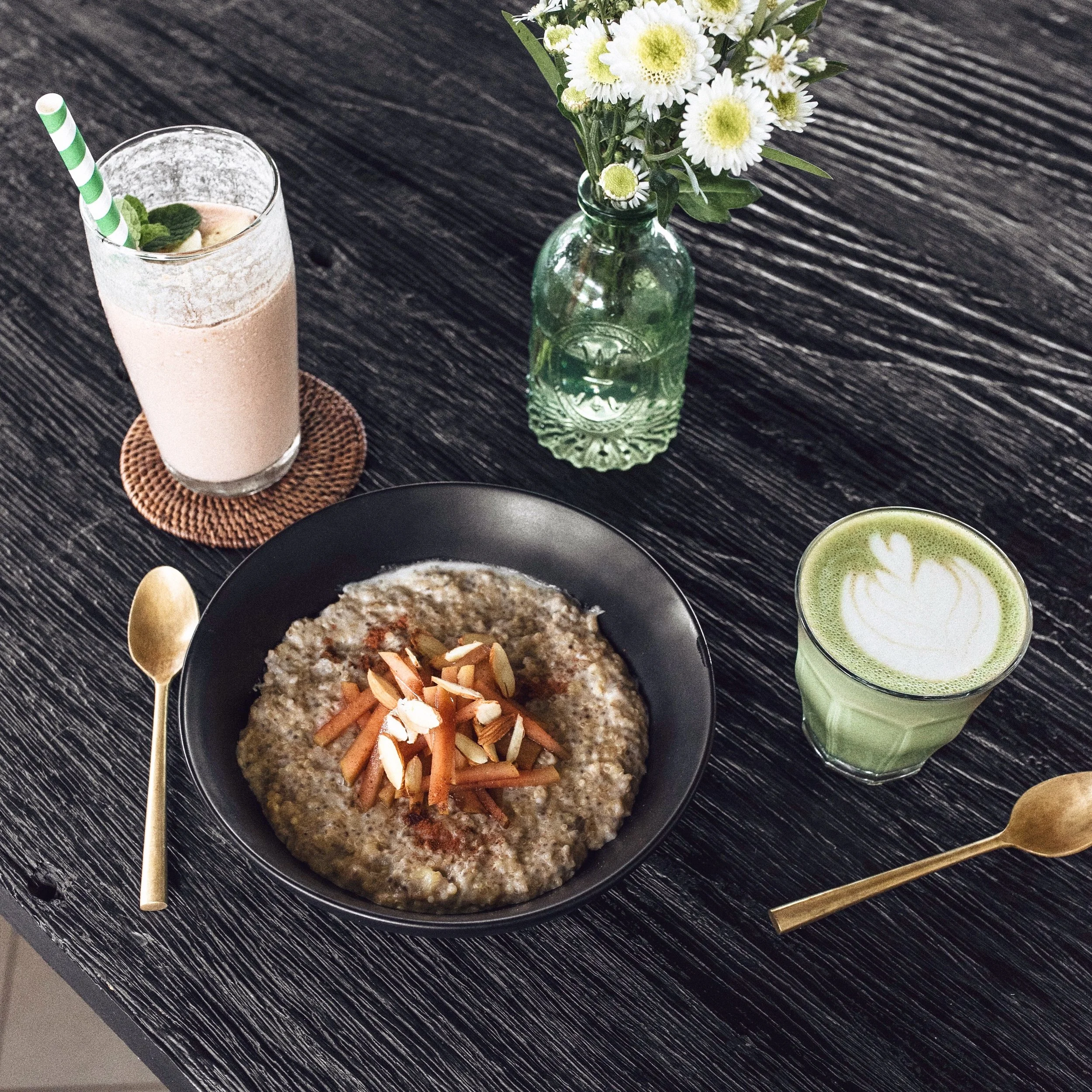 From left: chocolate smoothie, creamy quinoa porridge with cinnamon apples and almonds, and a chai matcha latte