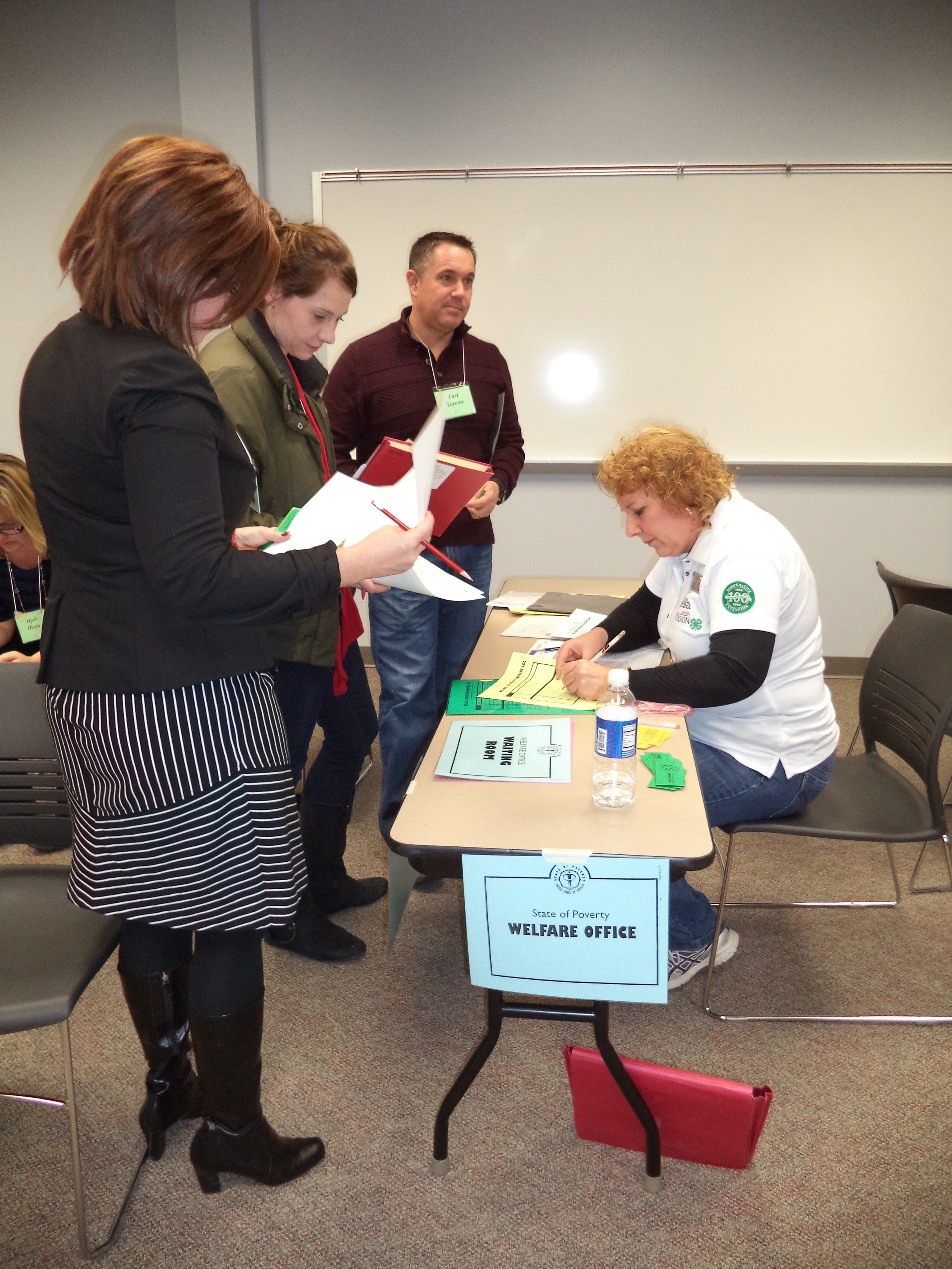 Poverty Simulation-Welfare Office-Tammy Peterson, Alex, Eric, Heidi.JPG