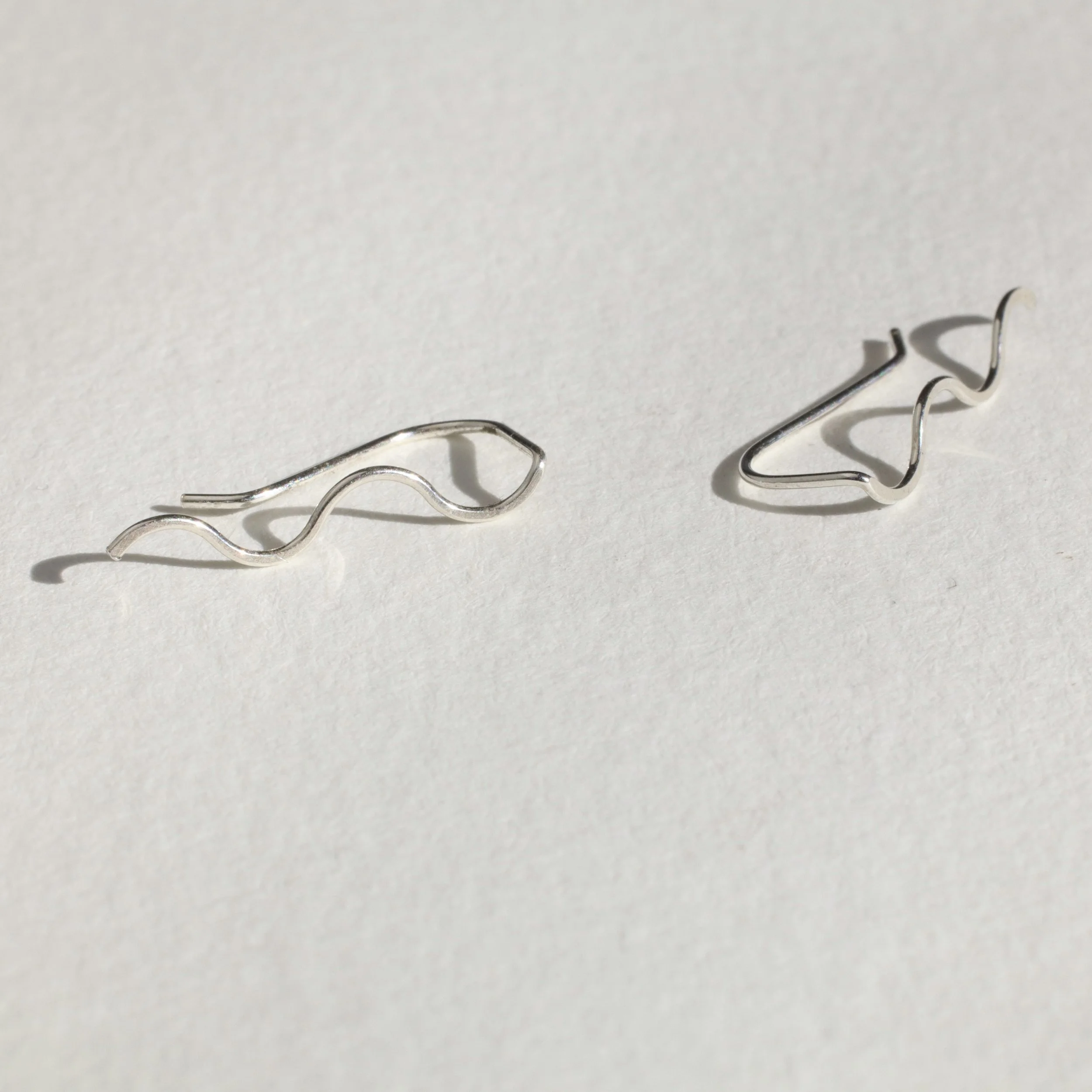 silver squiggle ear climbers on white with shadow.JPG
