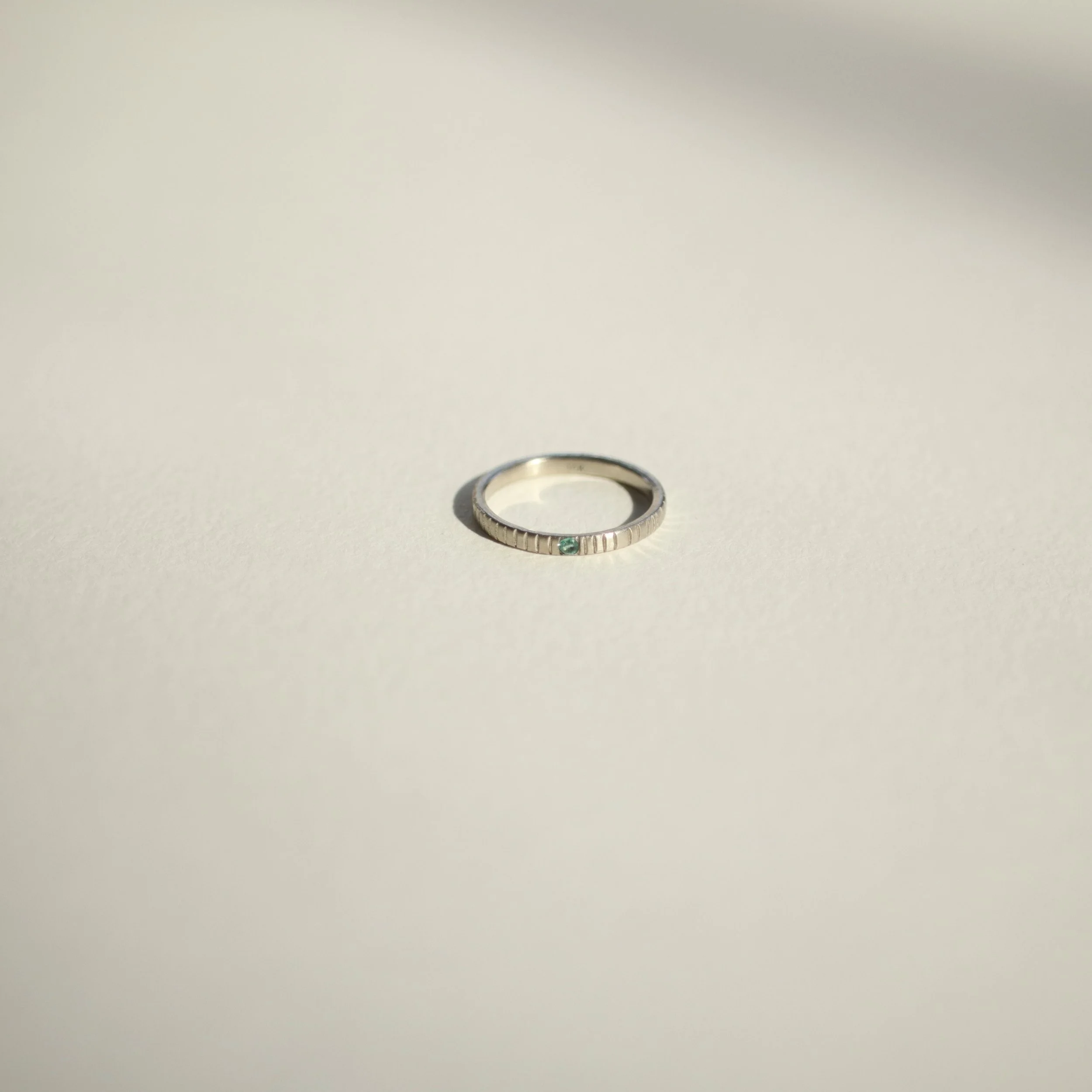 White gold lined emerald birthstone ring for Brecken