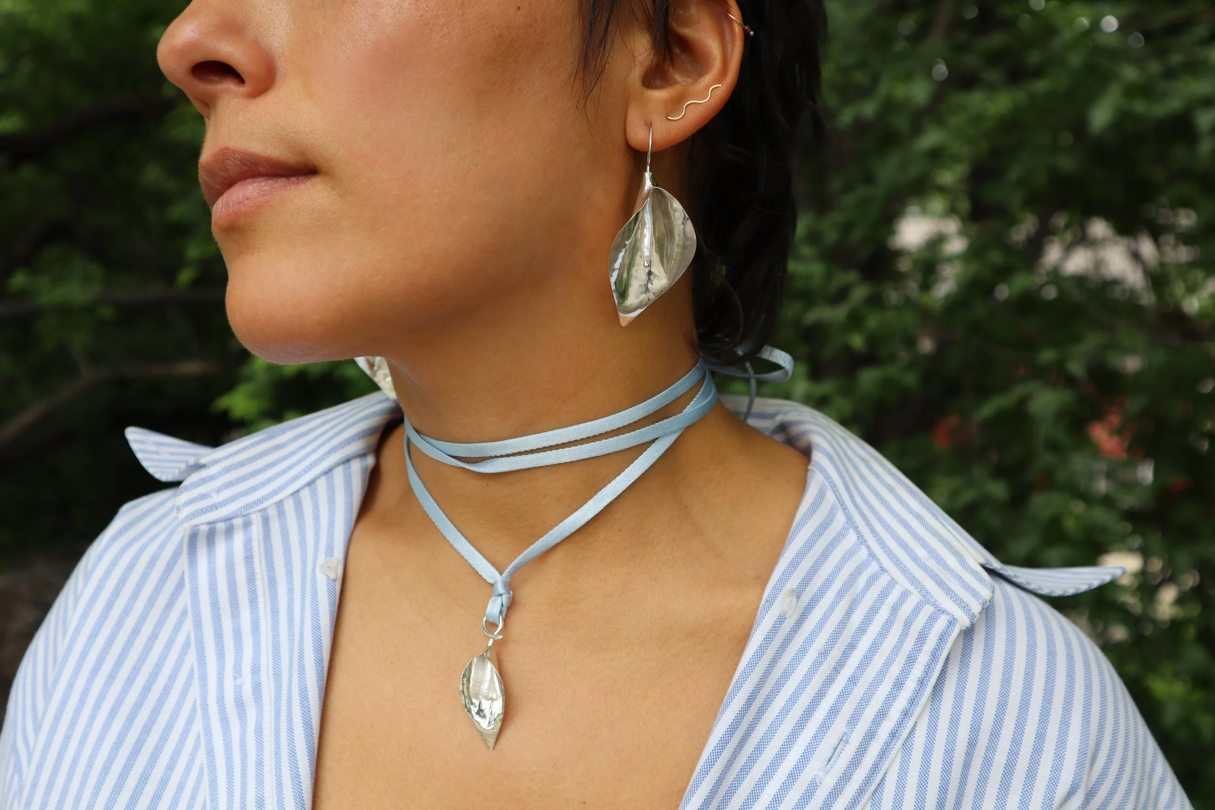 close up blue ribbon calla lily tie necklace and large calla lily earrings Sophie kissin Jewelry.jpeg