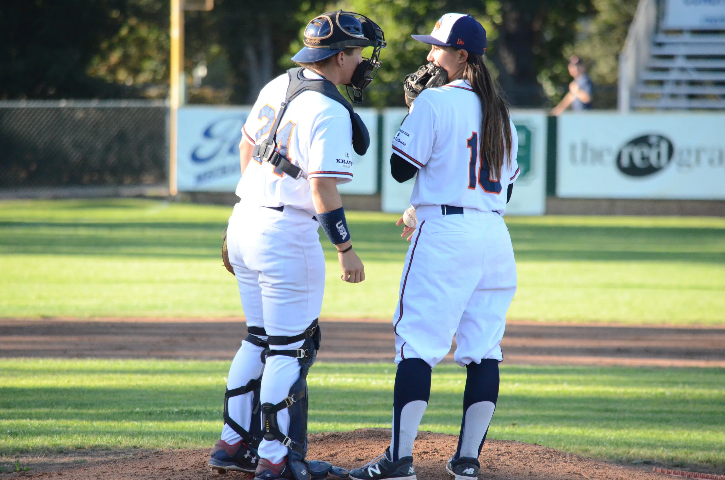 Anna Kimbrell, left, and Kelsie Whitmore, right, talk over strategy during Friday's game at People's Home Equity Ballpark in Sonoma, the first all-female battery in the history of men's professional baseball. James Toy III/Sonoma Stompers