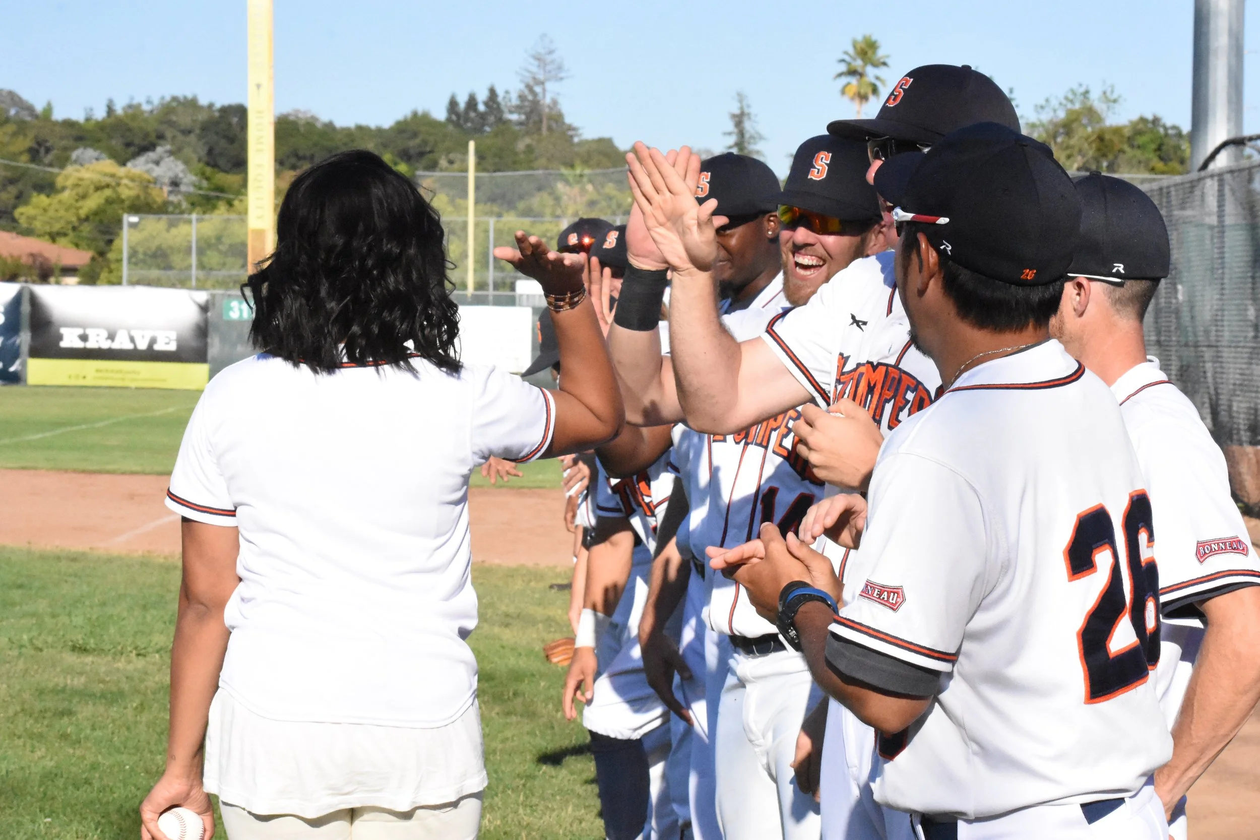 Author and professional chef Ayesha Curry (left) high fives the Sonoma Stompers after throwing the first pitch at Peoples Home Equity Ballpark at Arnold Field. (James W. Toy III / Sonoma Stompers)