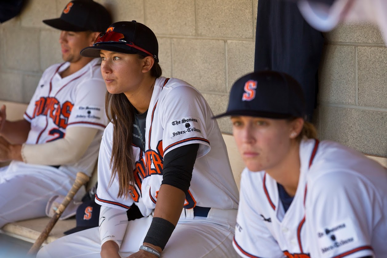 Kelsie Whitmore (center) and Stacy Piagno (right) sit in the dugout at Peoples Home Equity Ballpark at Arnold Field during the Stompers' 2016 Championship season. (James W. Toy III / Sonoma Stompers)