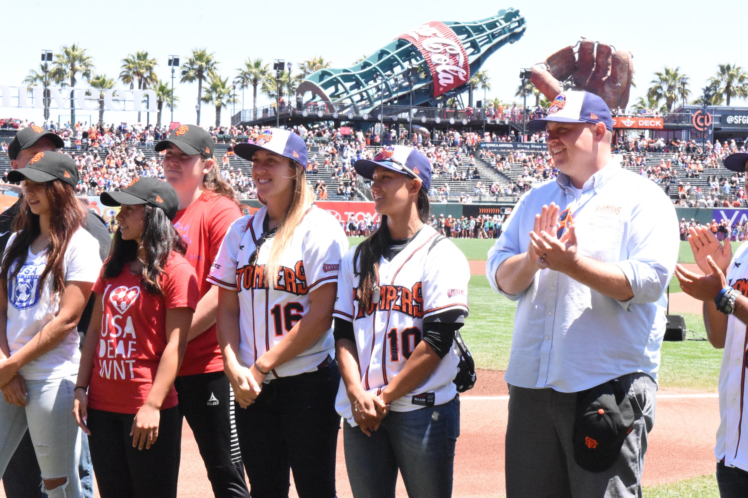 Stacy Piagno, Kelsie Whitmore, Theo Fightmaster and Takashi Miyoshi stand alongside the Women's Deaf National Soccer Team during a pre-game ceremony at AT&T Park on Sunday. (James W. Toy III / Sonoma Stompers)
