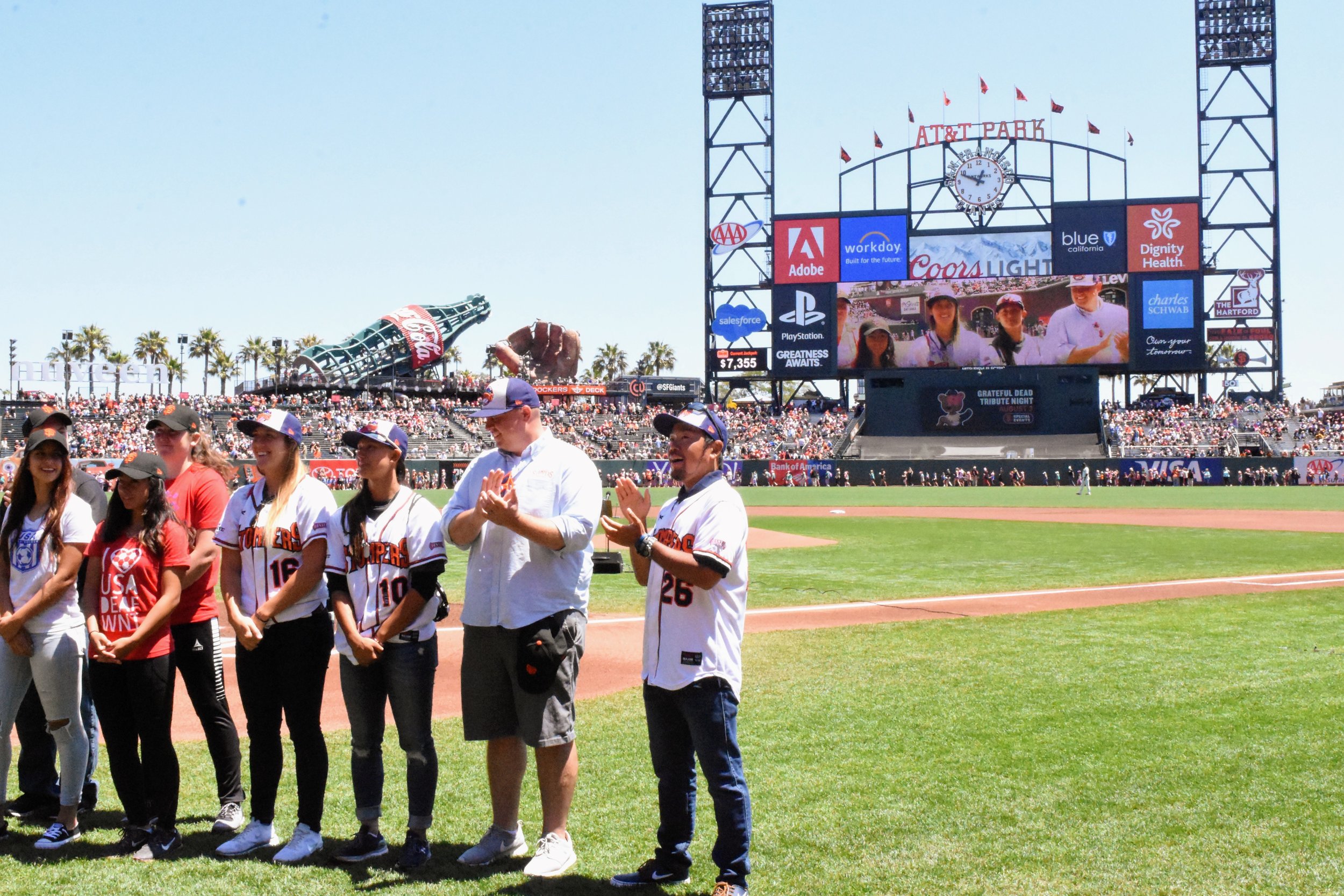  Stacy Piagno, Kelsie Whitmore,&nbsp;Theo Fightmaster and Takashi Miyoshi stand alongside the Women's Deaf National Soccer Team during a pre-game ceremony at AT&amp;T Park on Sunday. (James W. Toy III / Sonoma Stompers) 