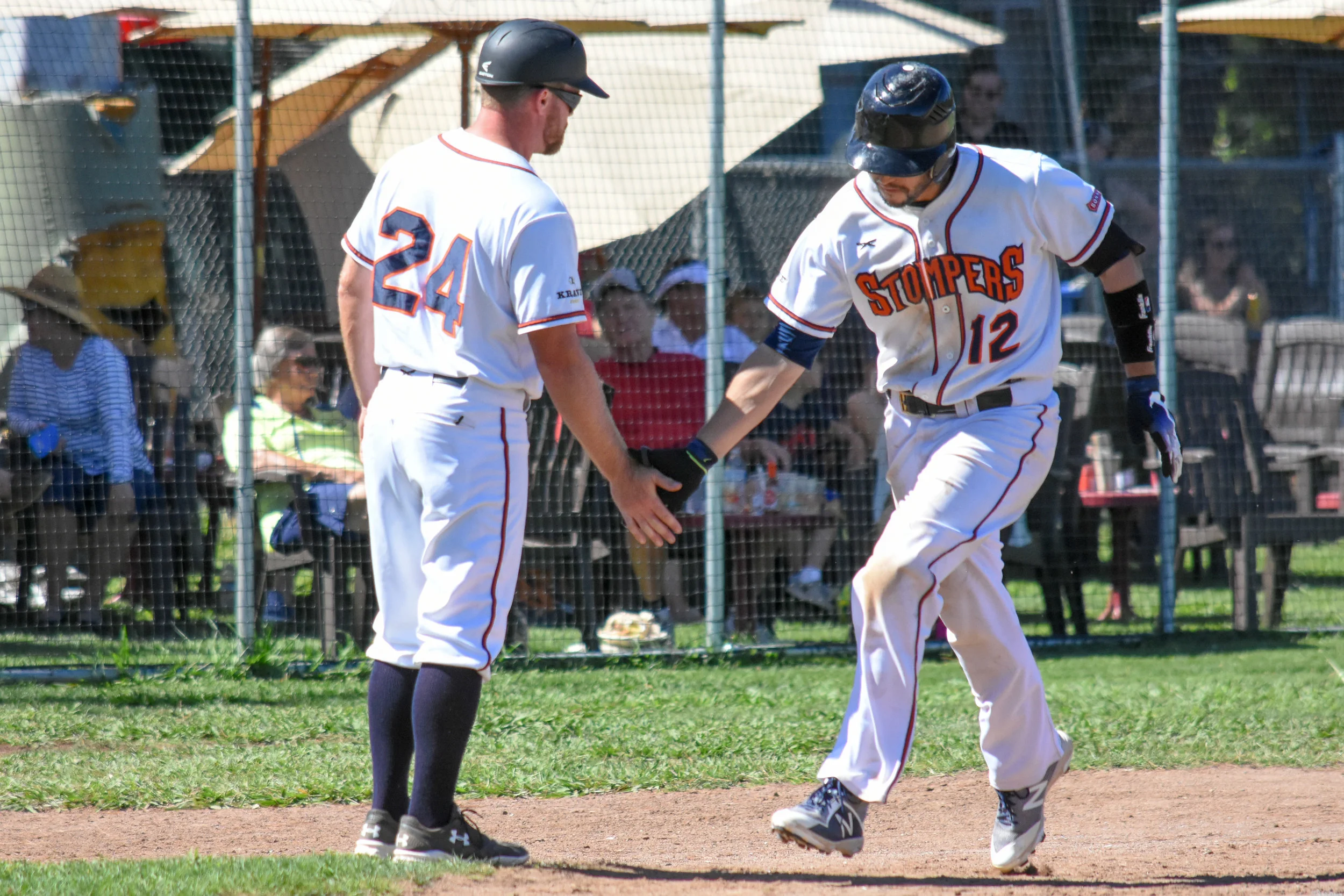 Kenny Meimerstorf (12) is greeted by manager Zack Pace (24) after hitting a solo home run in the seventh inning of the Sonoma Stompers game against the Martinez Clippers, August 5, 2018 in Sonoma, Calif.(James W. Toy III / Sonoma Stompers )