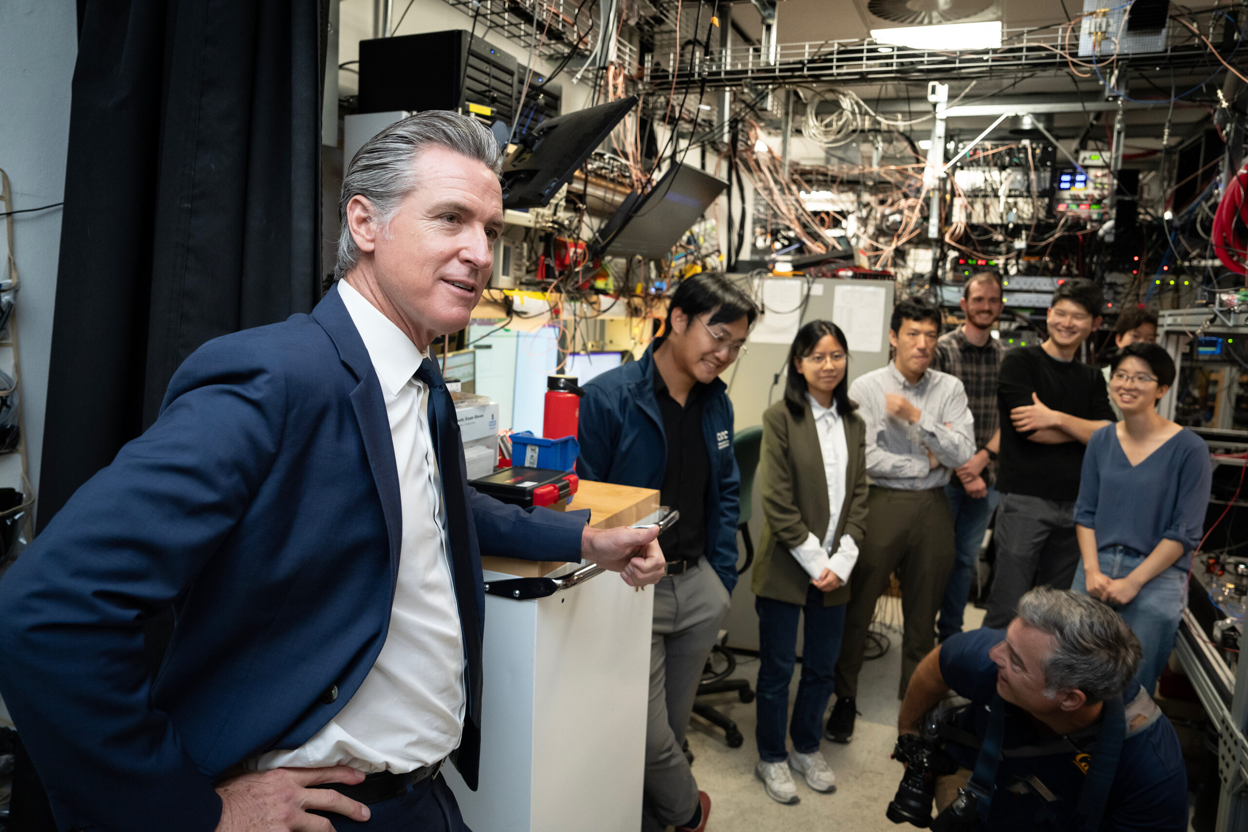 Governor Newsom in front of researchers in lab