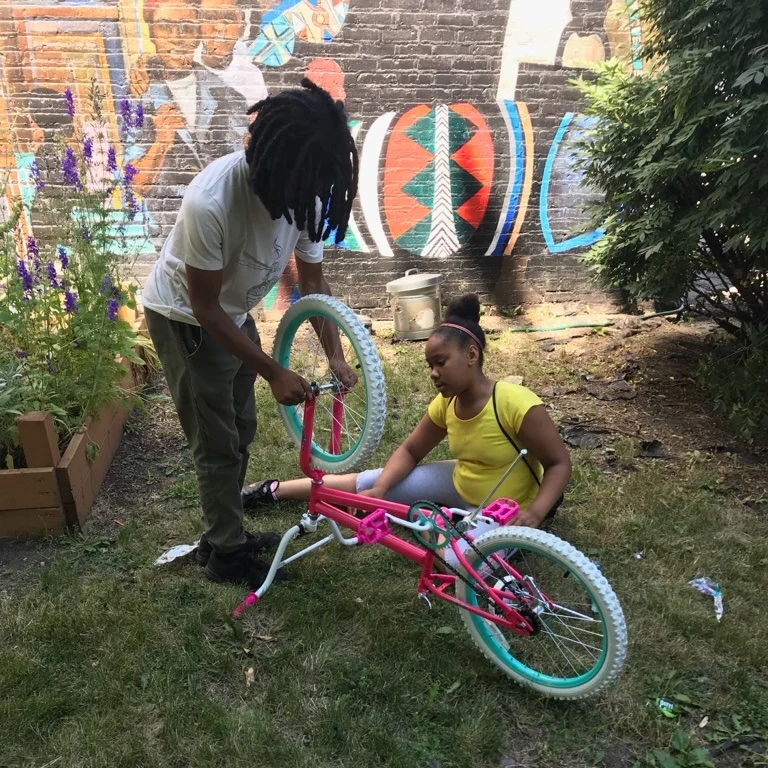 CYC teens work on assembling a bike.