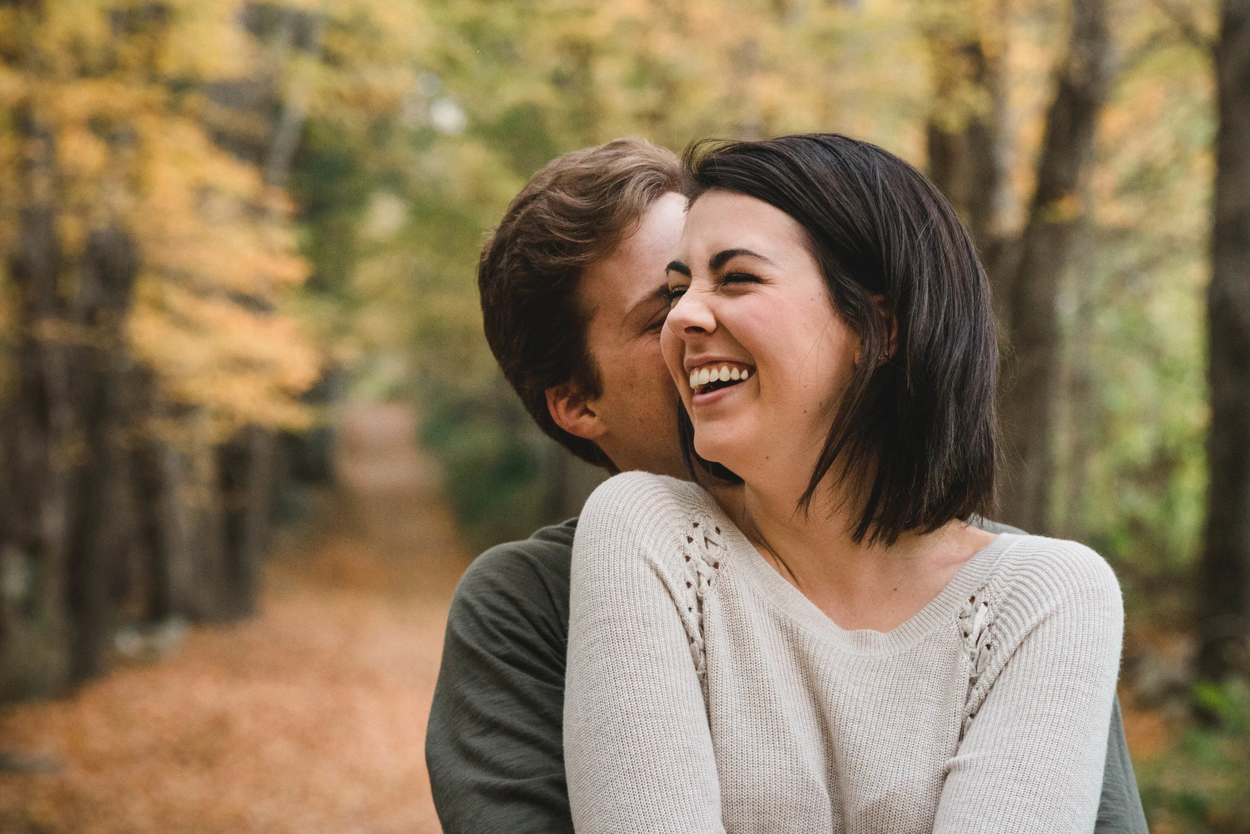 couple snuggling in New England fall foliage