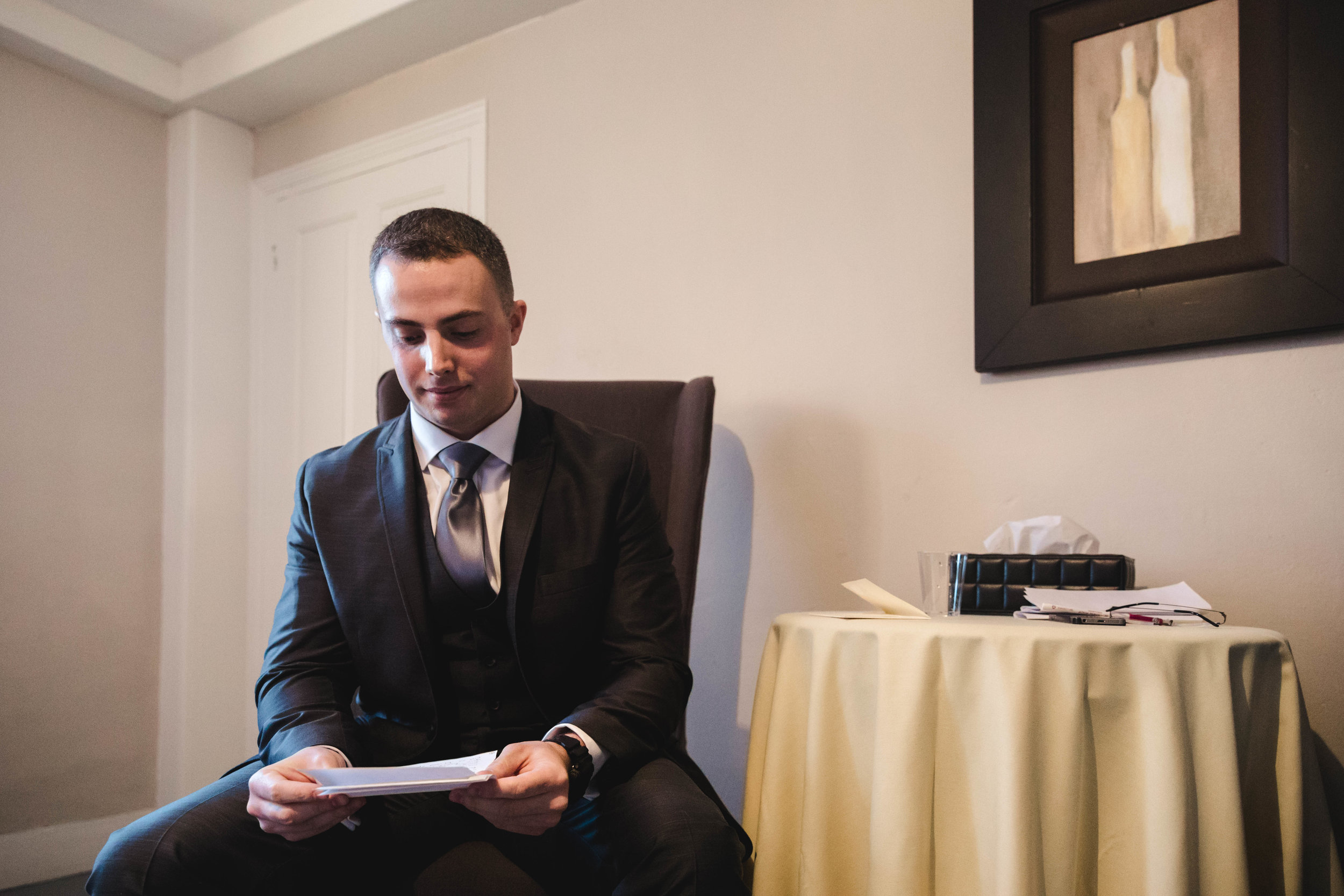 groom reading letter from bride before ceremony