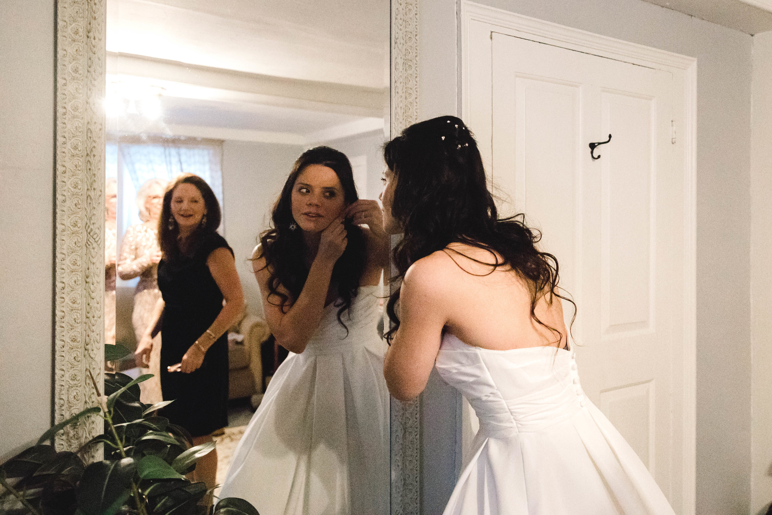 Bride putting on earrings before wedding