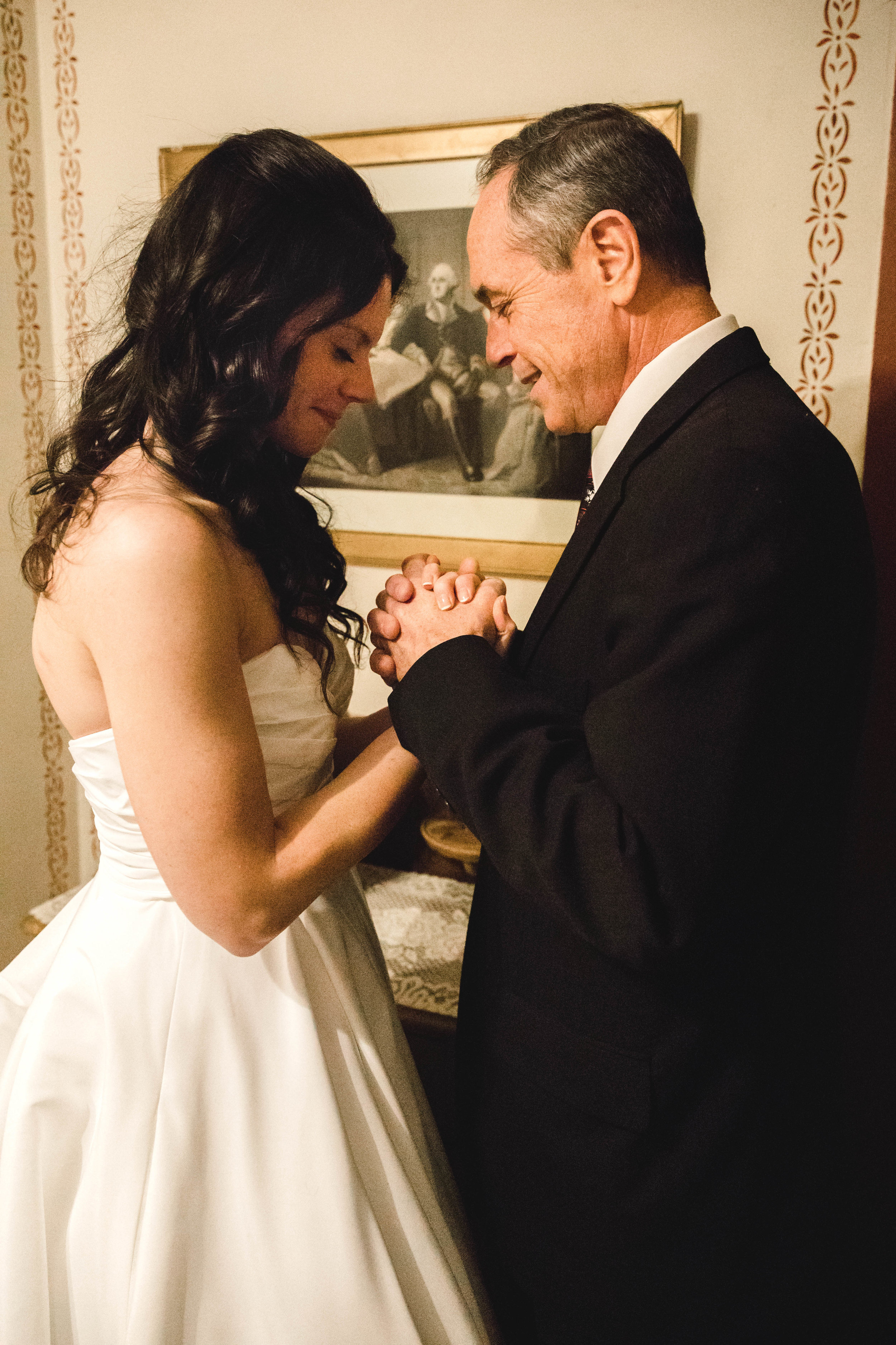 bride and father praying before wedding ceremony