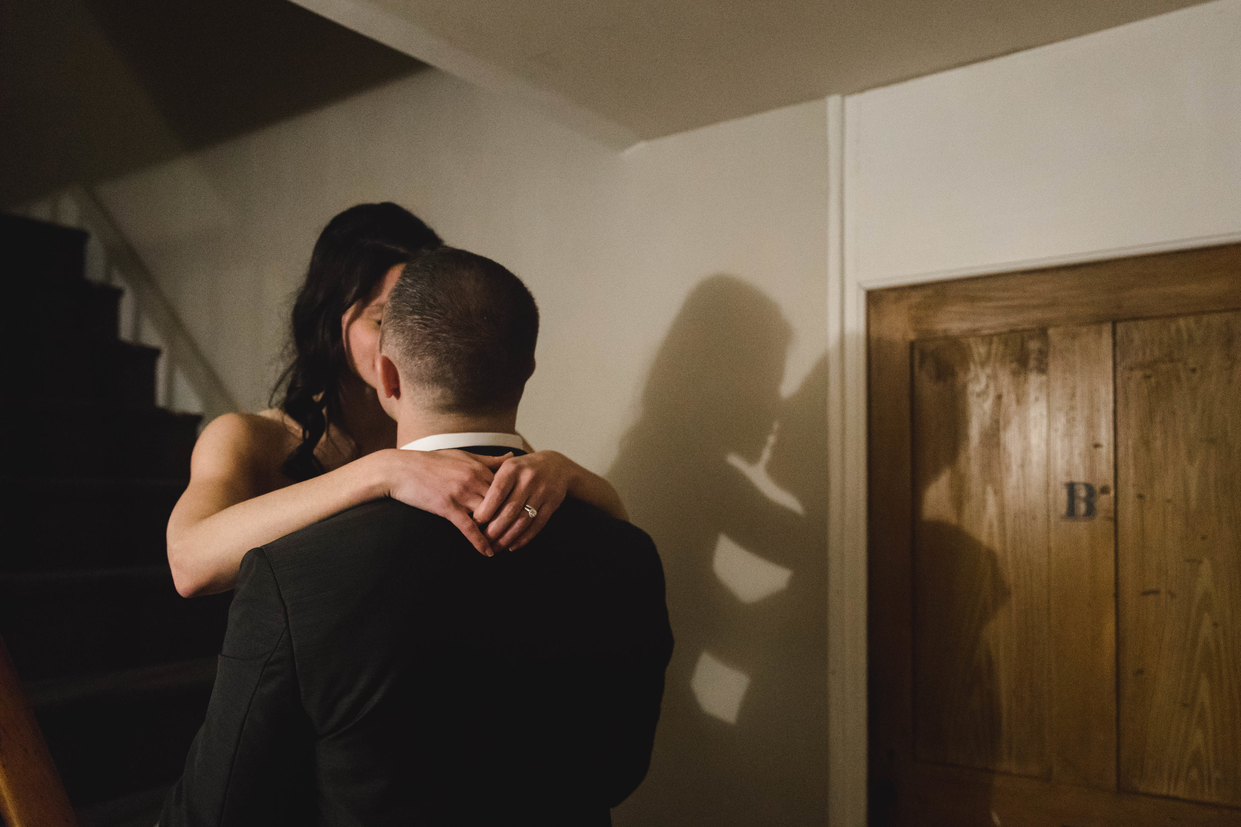 bride and groom kiss with shadow on wall