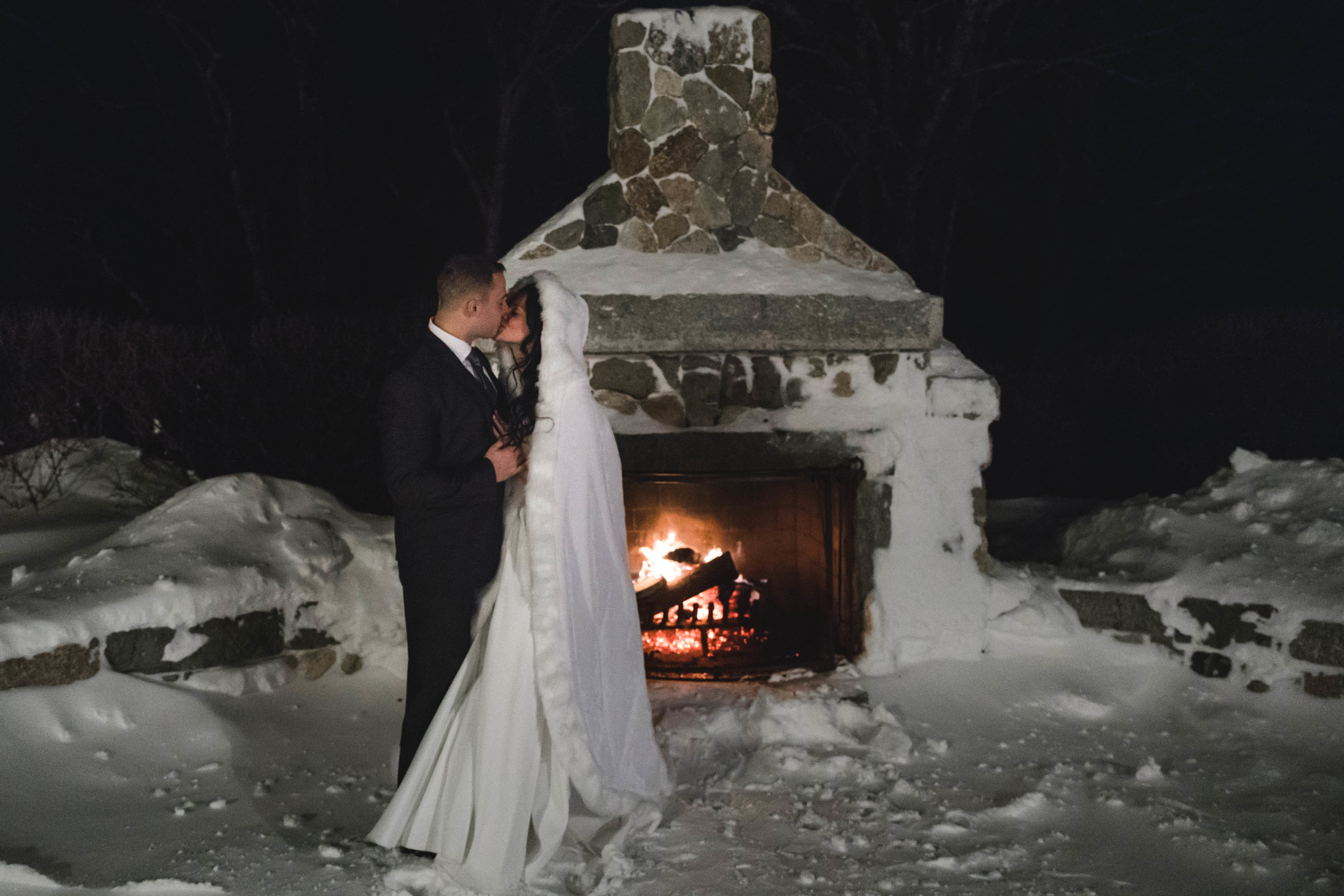harrington farm outdoor fireplace at winter wedding with bride and groom