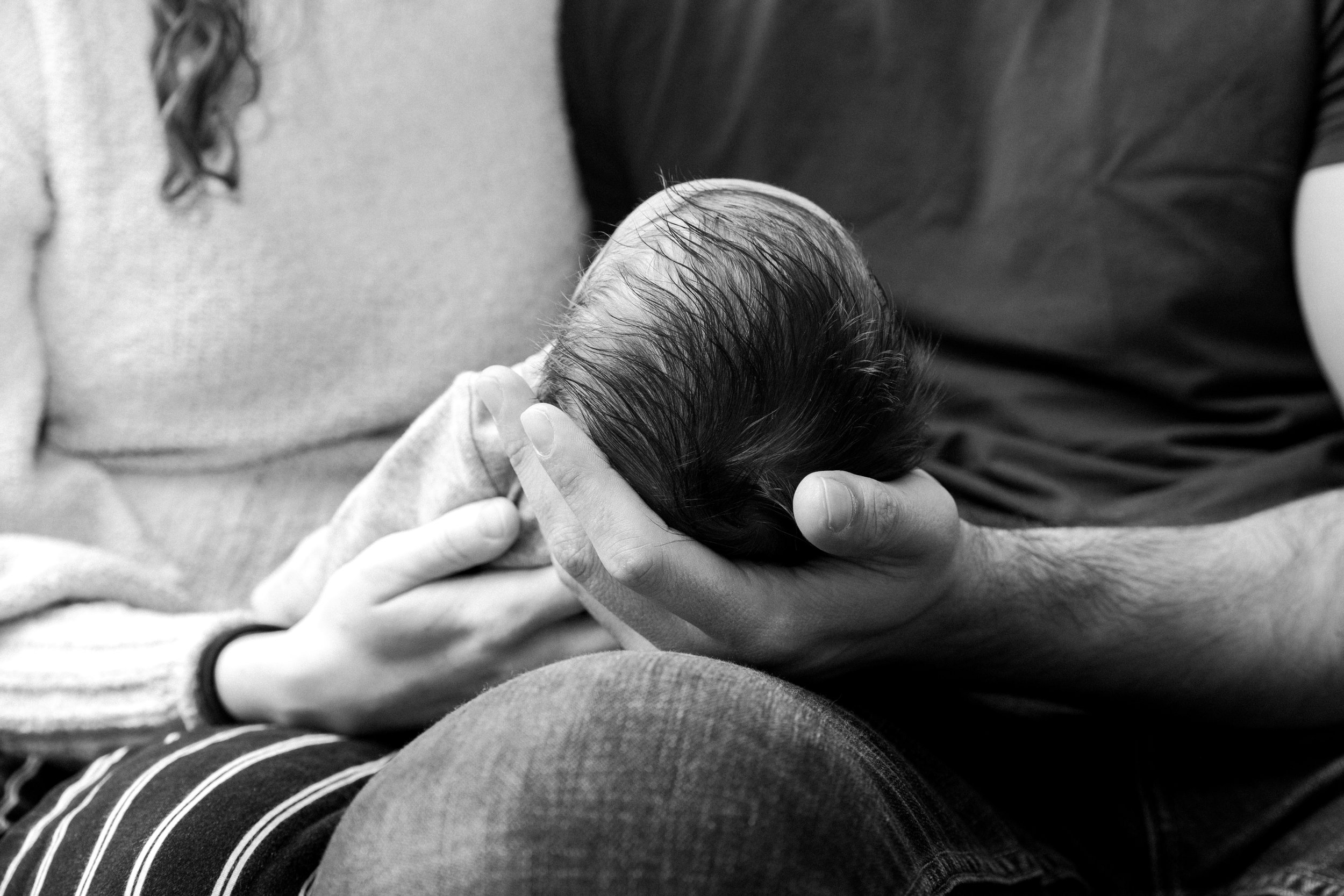 black &amp; white photo of new parents holding baby 