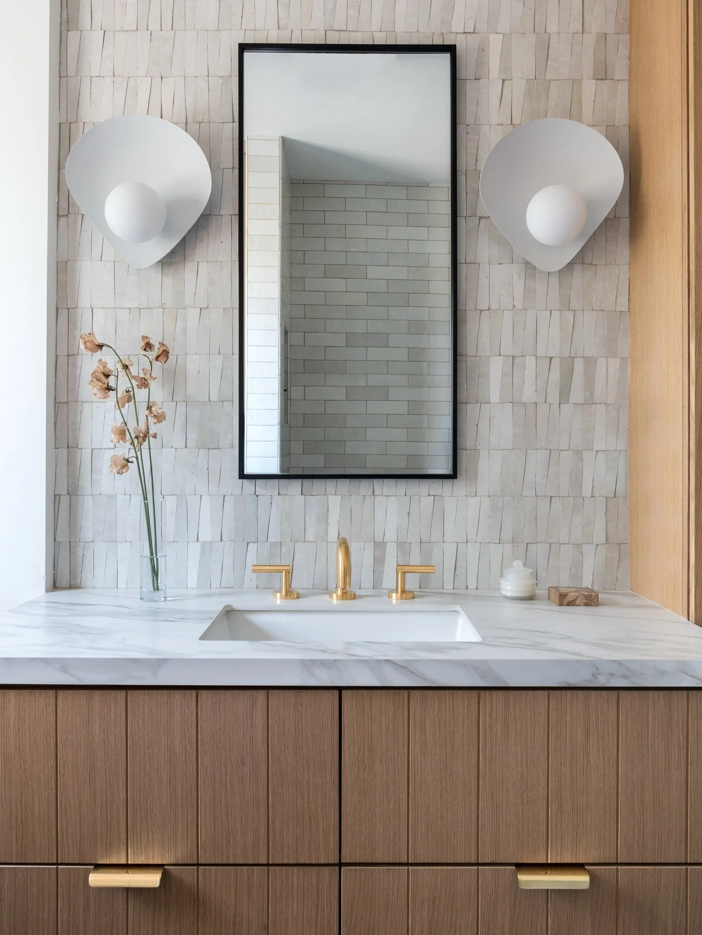 In this compact bath, every inch was considered! Custom cabinetry maximizes storage while keeping the space feeling clean and intentional.

We paired the white oak cabientry with handmade white zellige, bringing in subtle movement and tonal variation