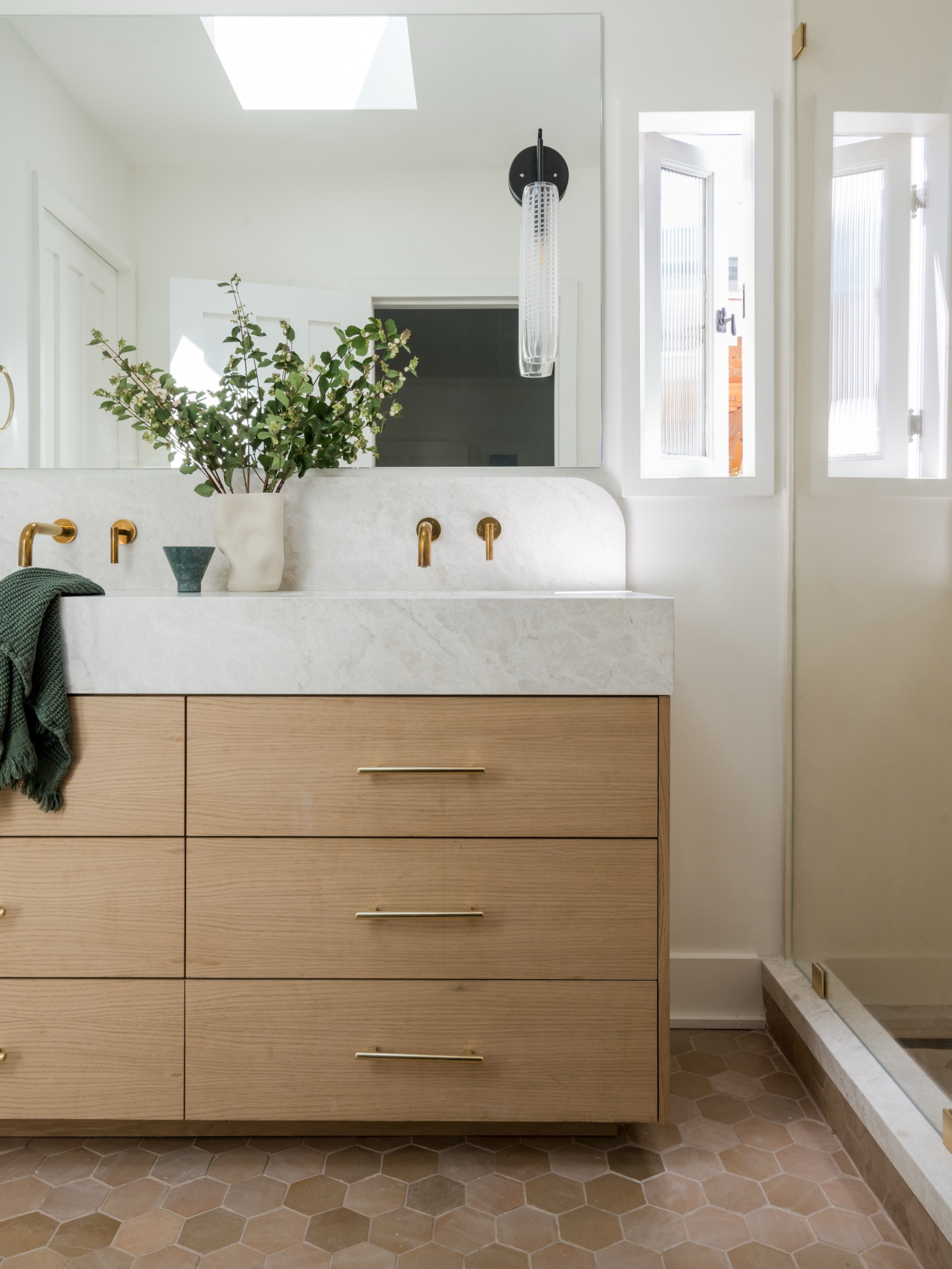 The curve in the marble backsplash makes the whole room. It&rsquo;s a quiet detail, but it softens everything: pulling the oak vanity, custom mirror, and tadelakt shower into one cohesive moment.

It&rsquo;s the kind of restraint that elevates a luxu
