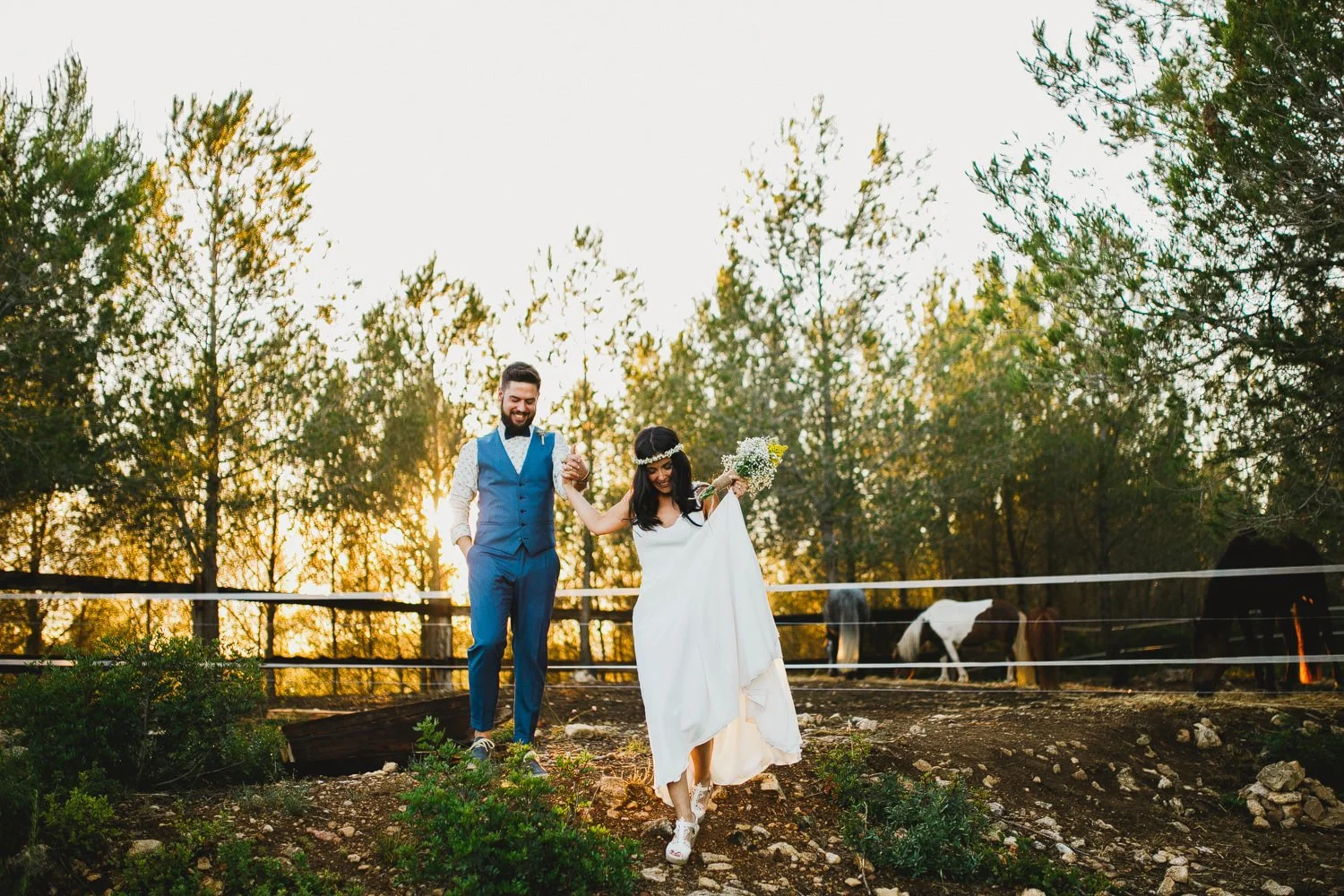 Bride twirling at golden hour at Masia Pou de la Vinya, with horses and backlit olive trees — documentary wedding photography near Barcelona