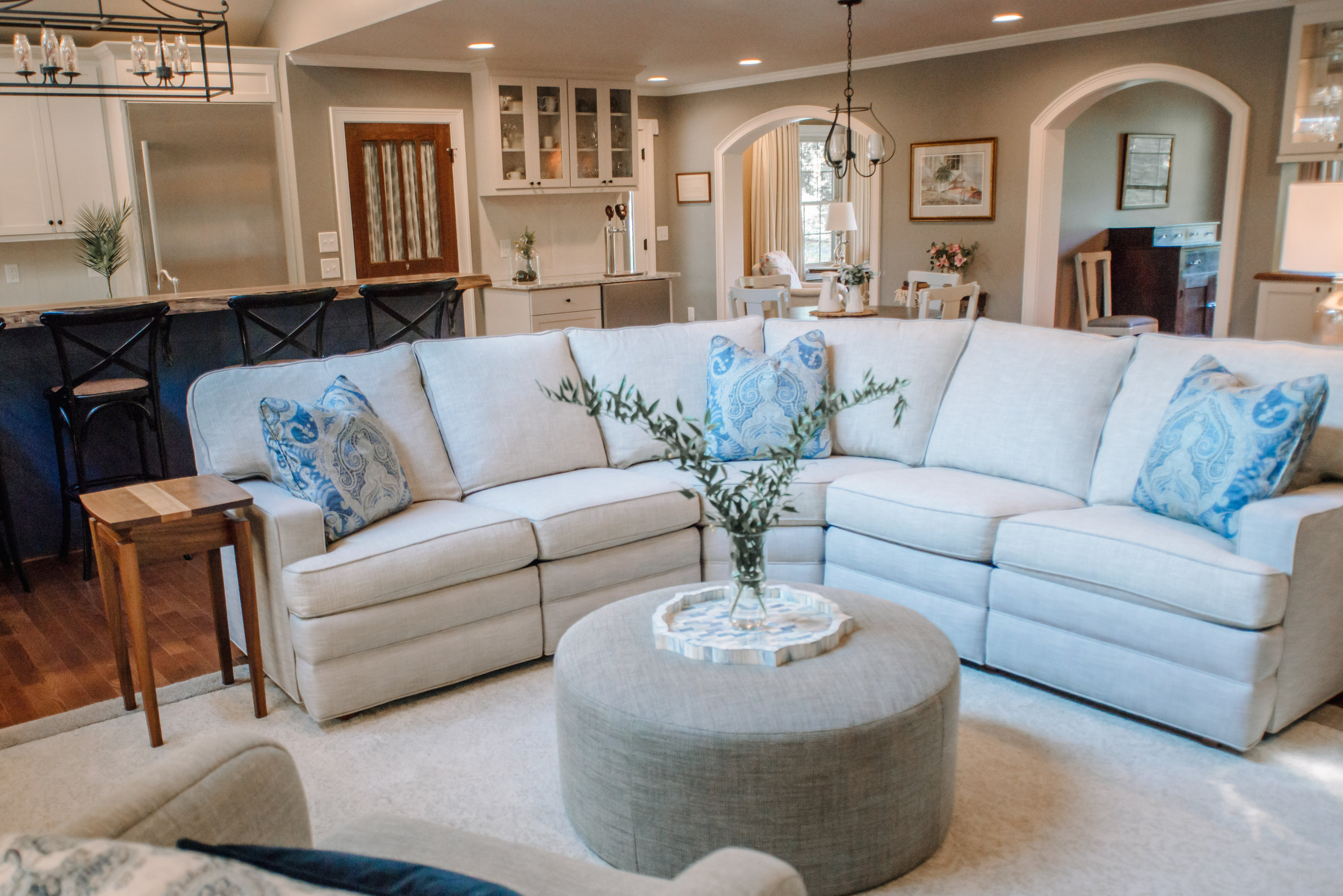 Transitional white &amp; gray family room design featuring Motioncraft sectional and upholstered ottoman by NC Lake Norman interior designer, 180 Spaces.