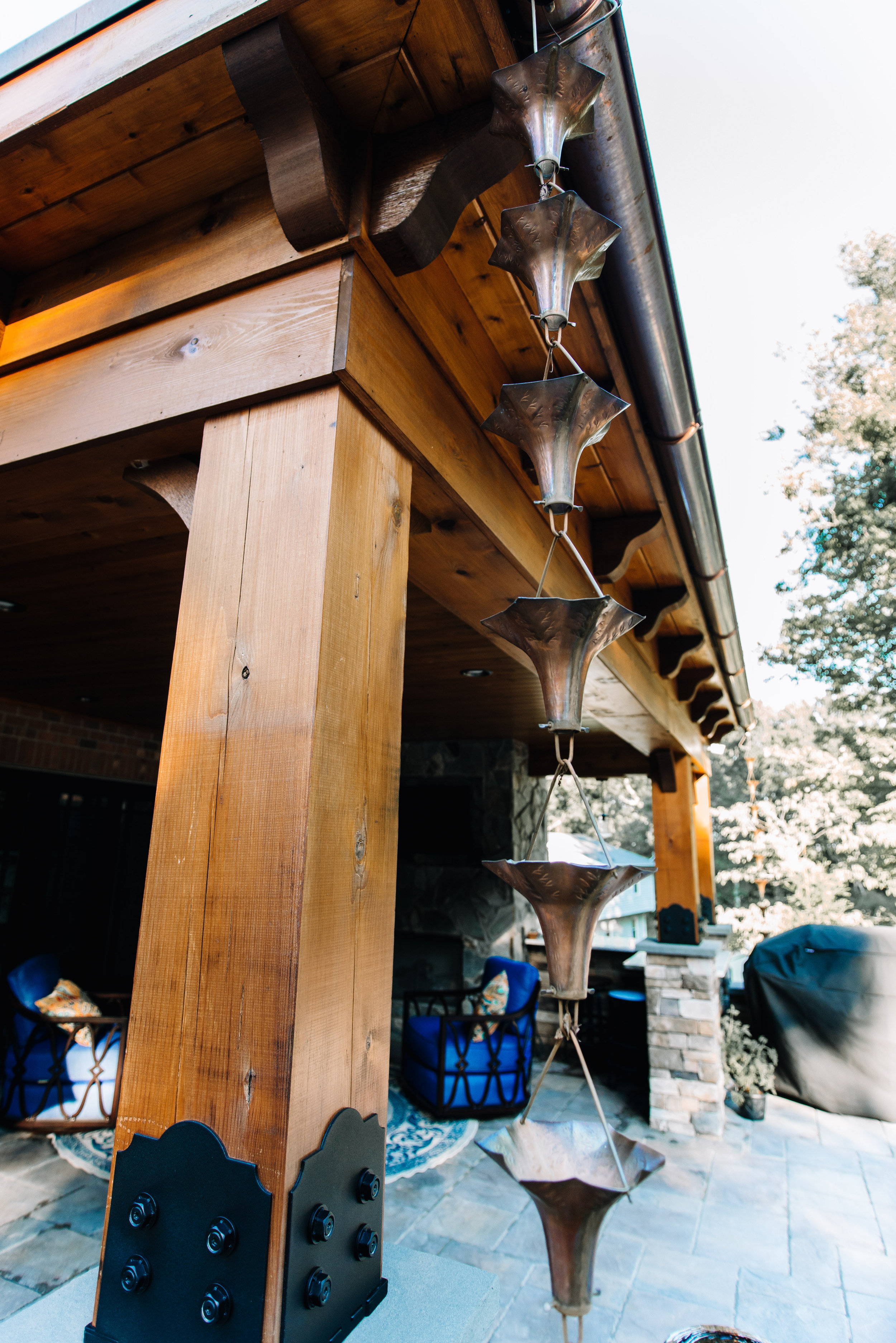 Outdoor lanai design featuring custom red cedar posts and cooper rain chains. All design by NC Lake Norman Interior Designer, 180 Spaces. 