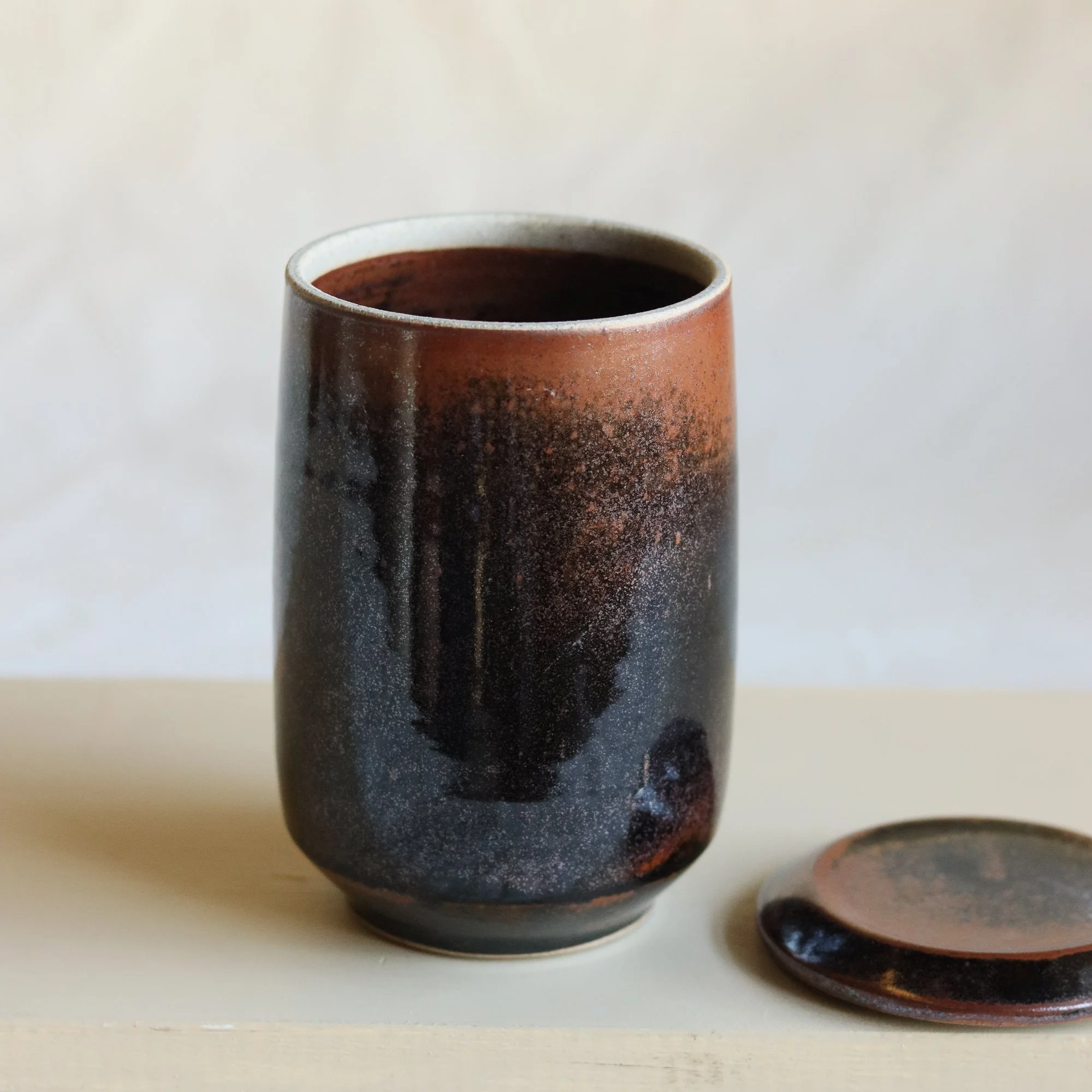 Dark brown traditional tenmoku lidded jar by Pottery West