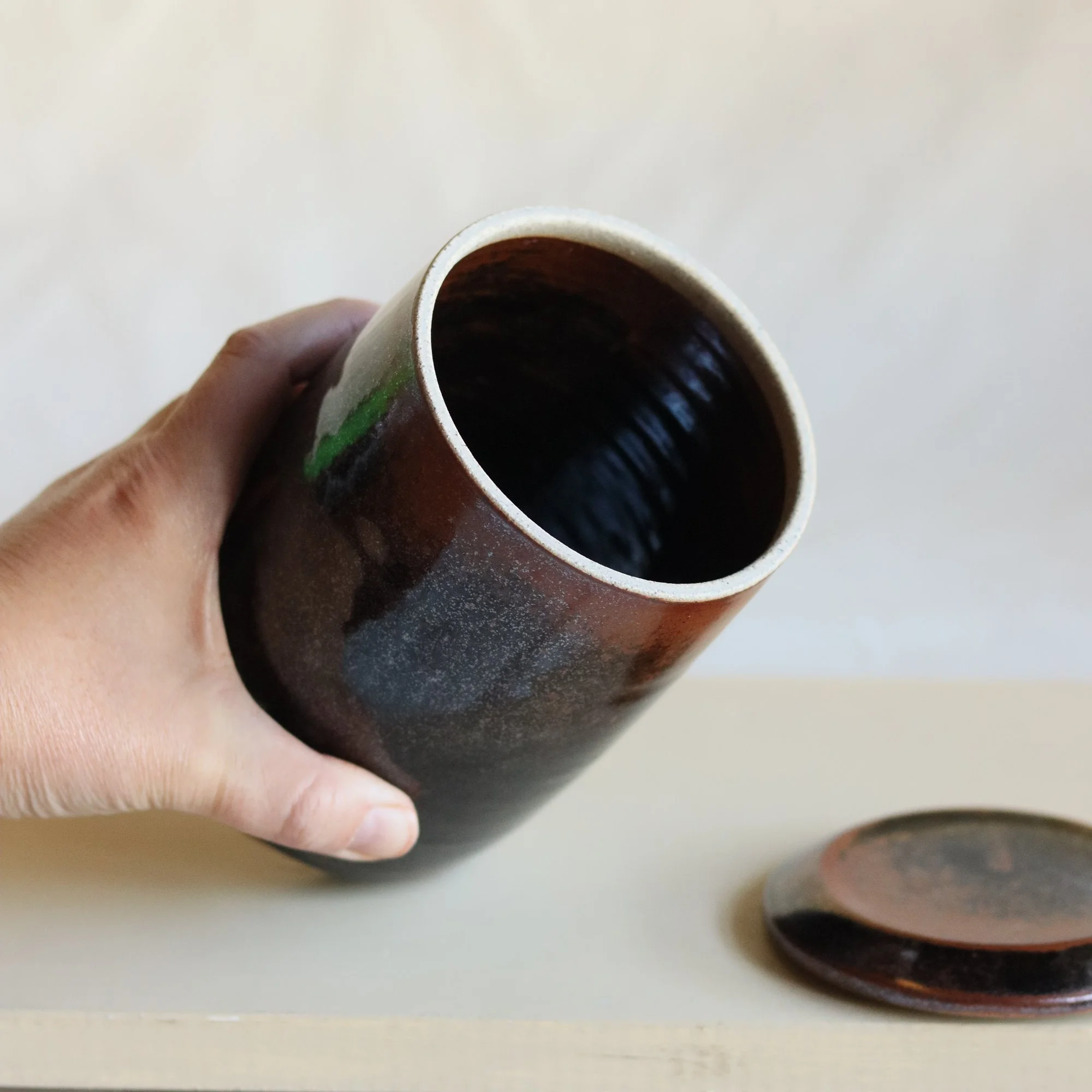 Hand holding a handmade pottery jar