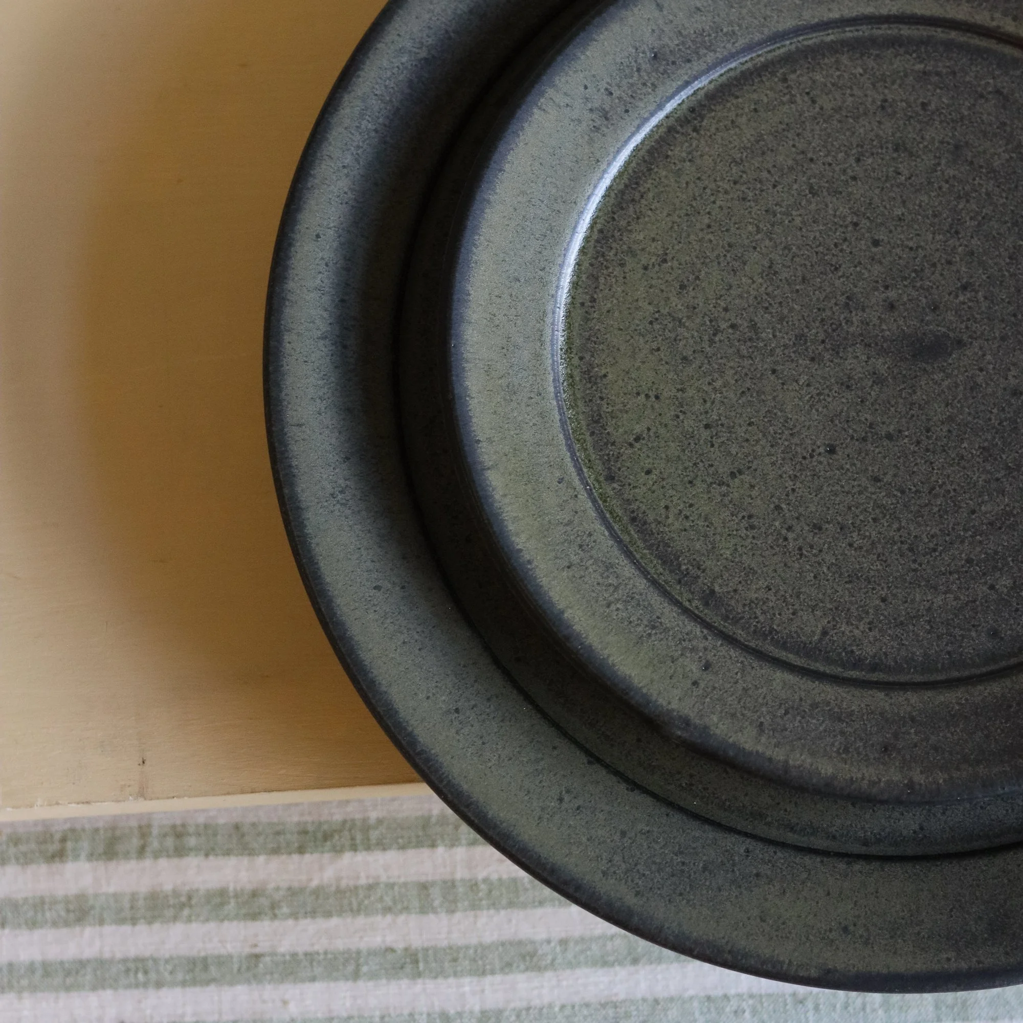 Stoneware side plate thrown at the wheel and glazed in a matte black glaze
