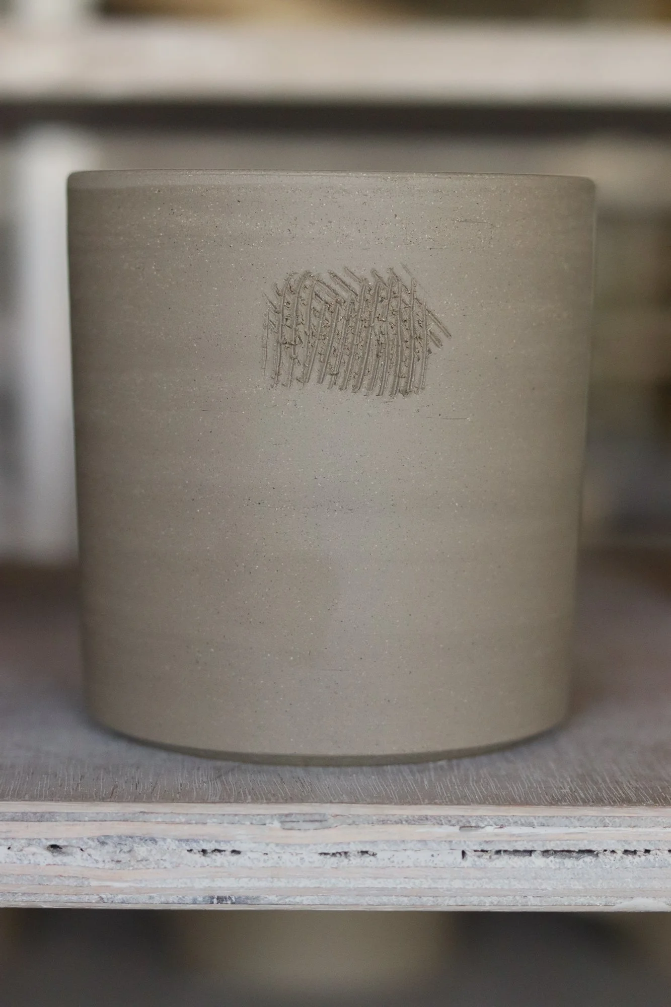 Making grooves before adding slip and handles on our classic mugs