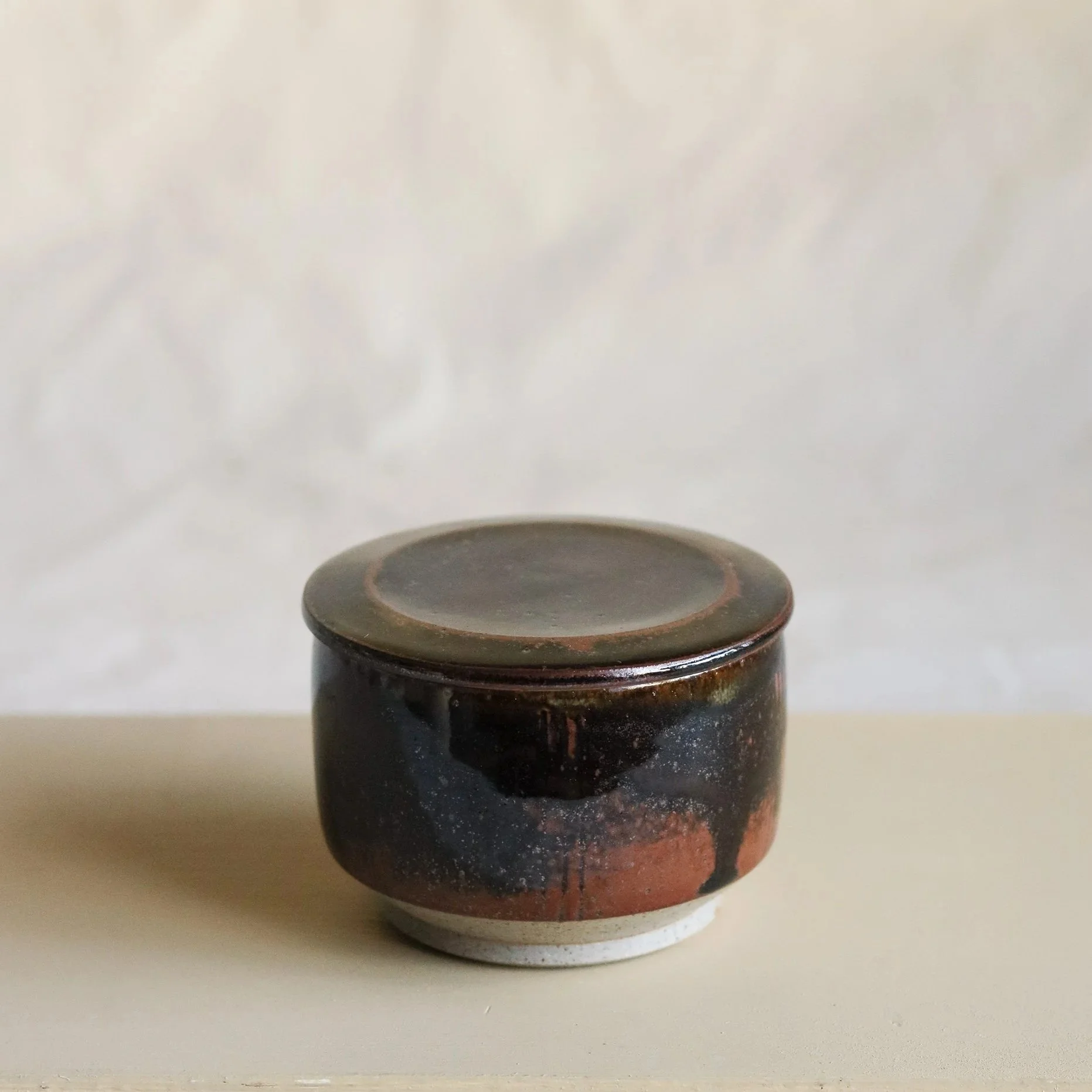 Small stoneware lidded jar in tenmoku by Pottery West