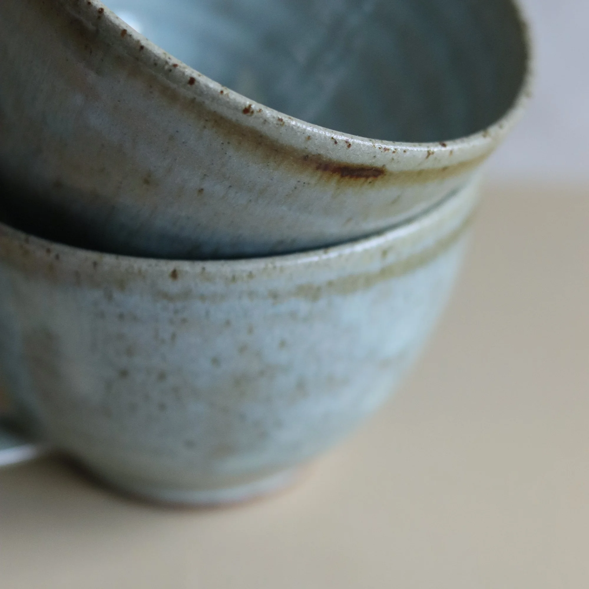 Iron oxide brushwork detail on the curved mugs by Pottery West