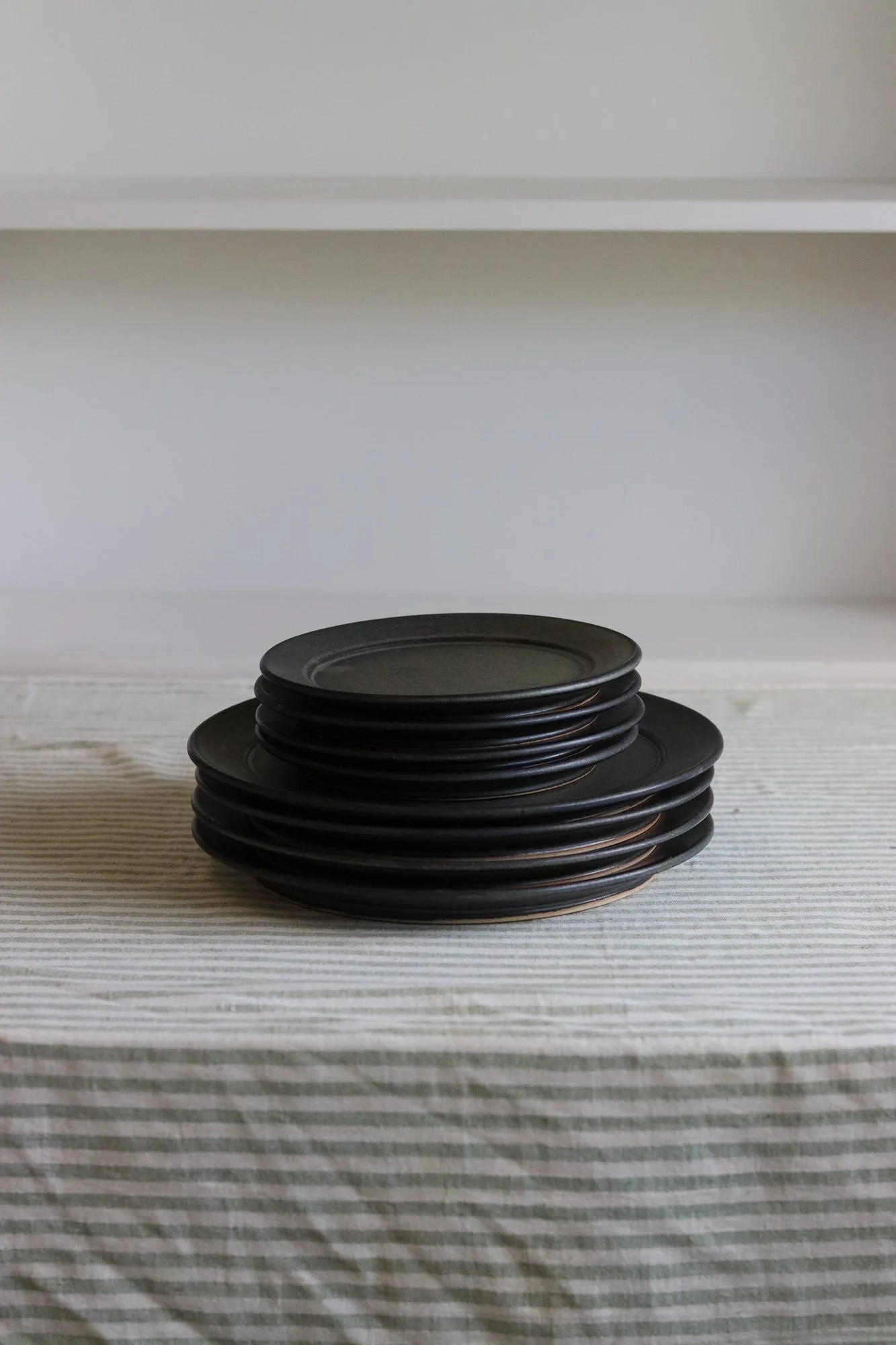 Stoneware side plate thrown at the wheel and glazed in a matte black glaze