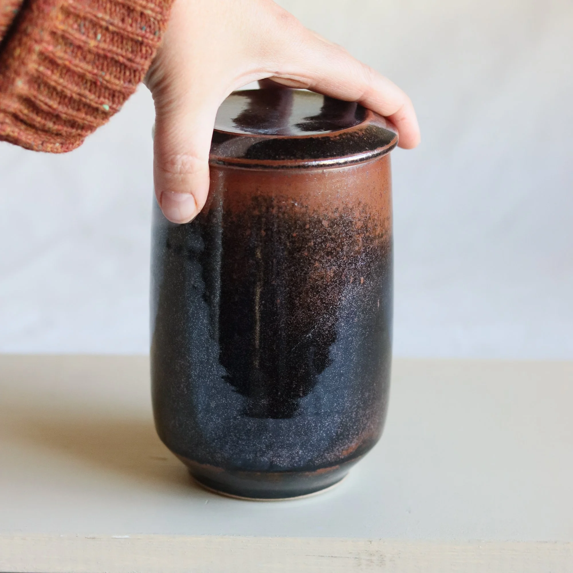 Fully glazed tenmoku lidded jar by Catherine and Matt West